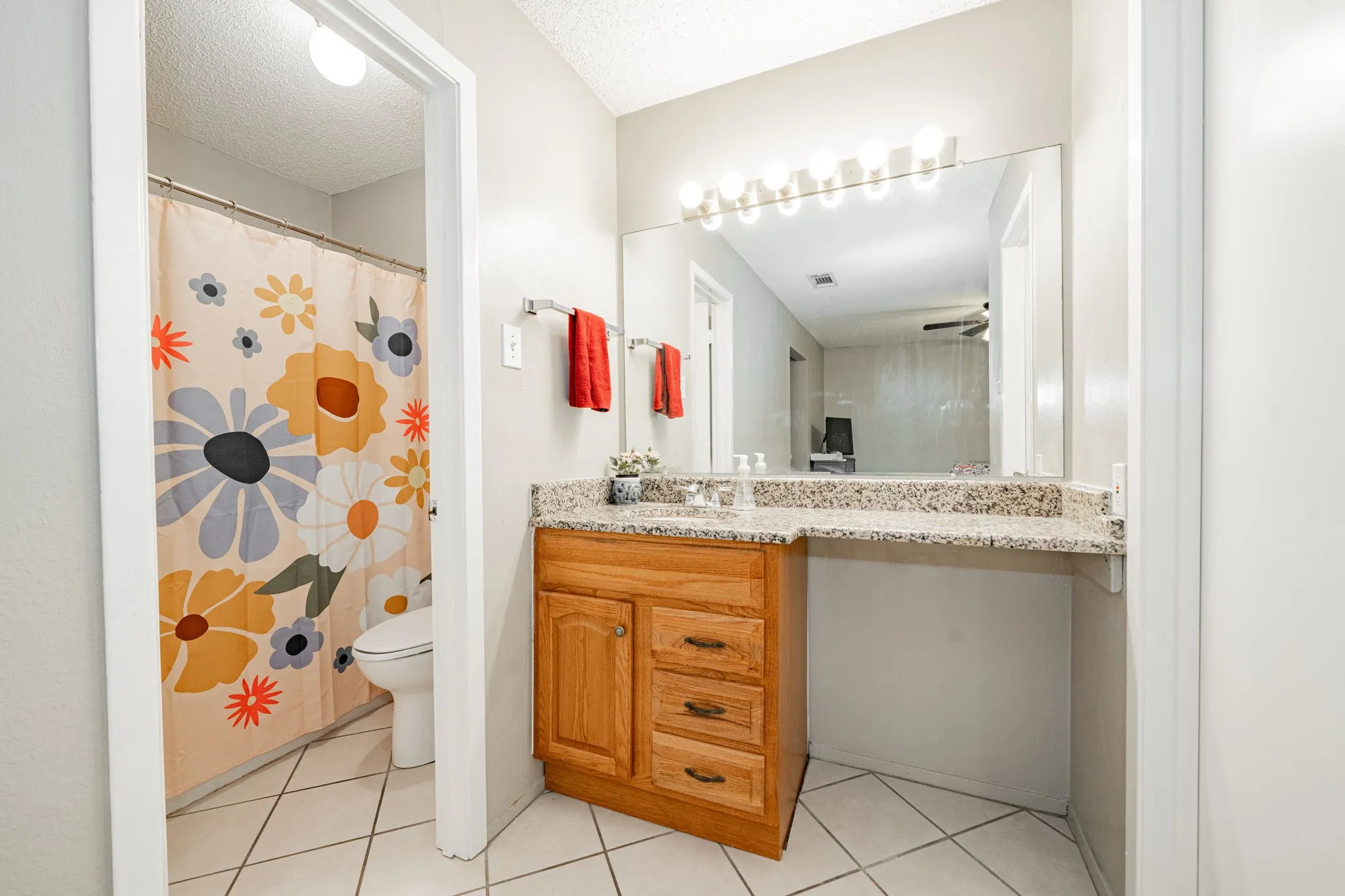 Bathroom vanity with a granite-style countertop, integrated sink, and wood-finish cabinetry