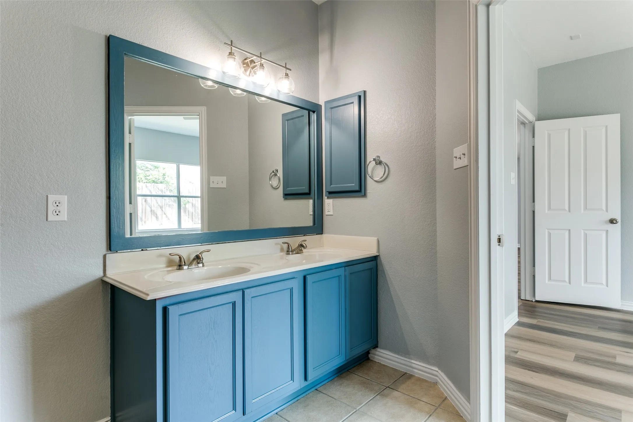 Dual sink vanity with blue cabinetry and white countertops