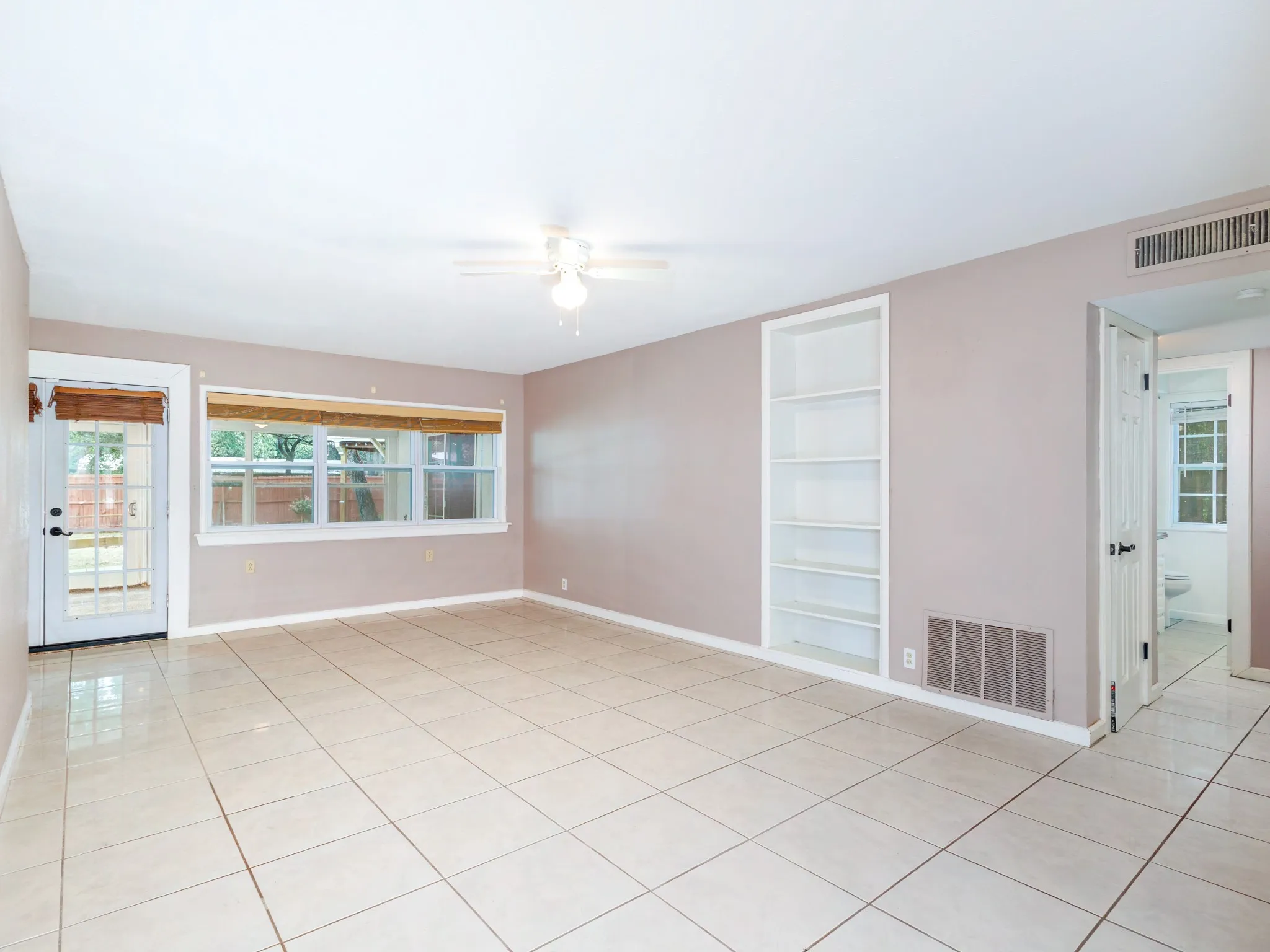 Living area and sunroom in the back. the hallway to the bedrooms on the right.