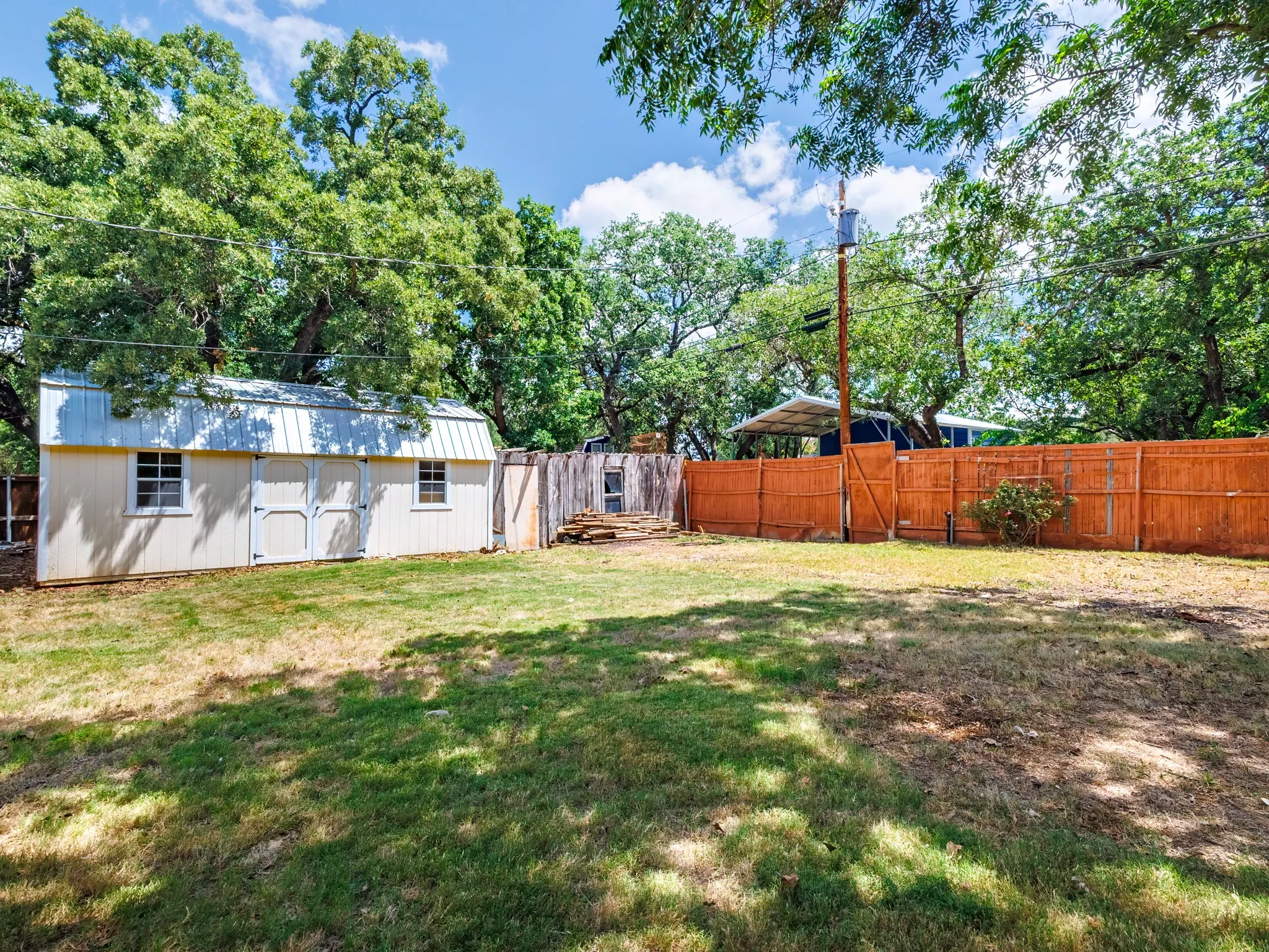 Back yard with storage building that would make a great craft or hobby room.