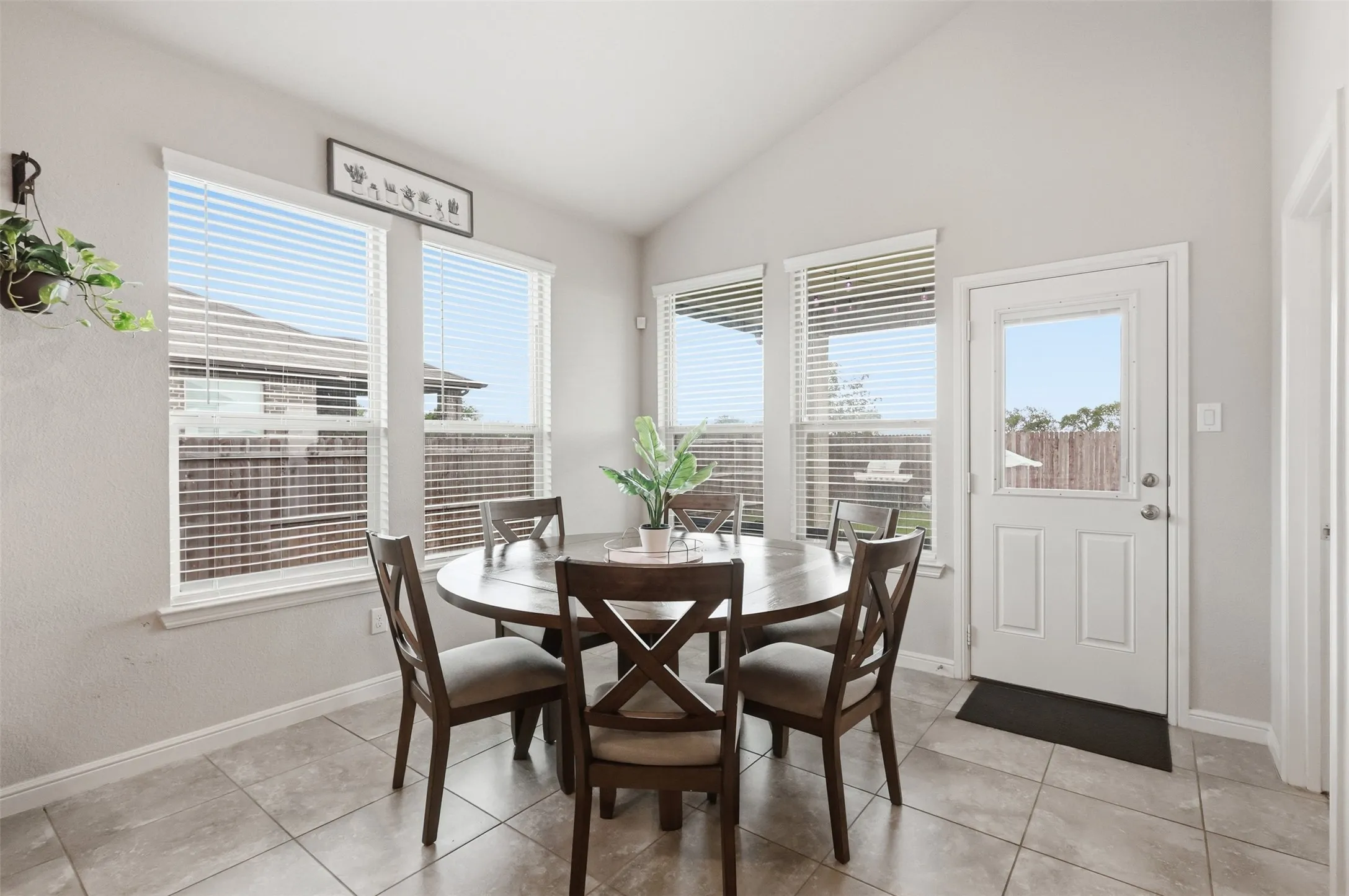 Dining area featuring a vaulted ceiling and tile flooring