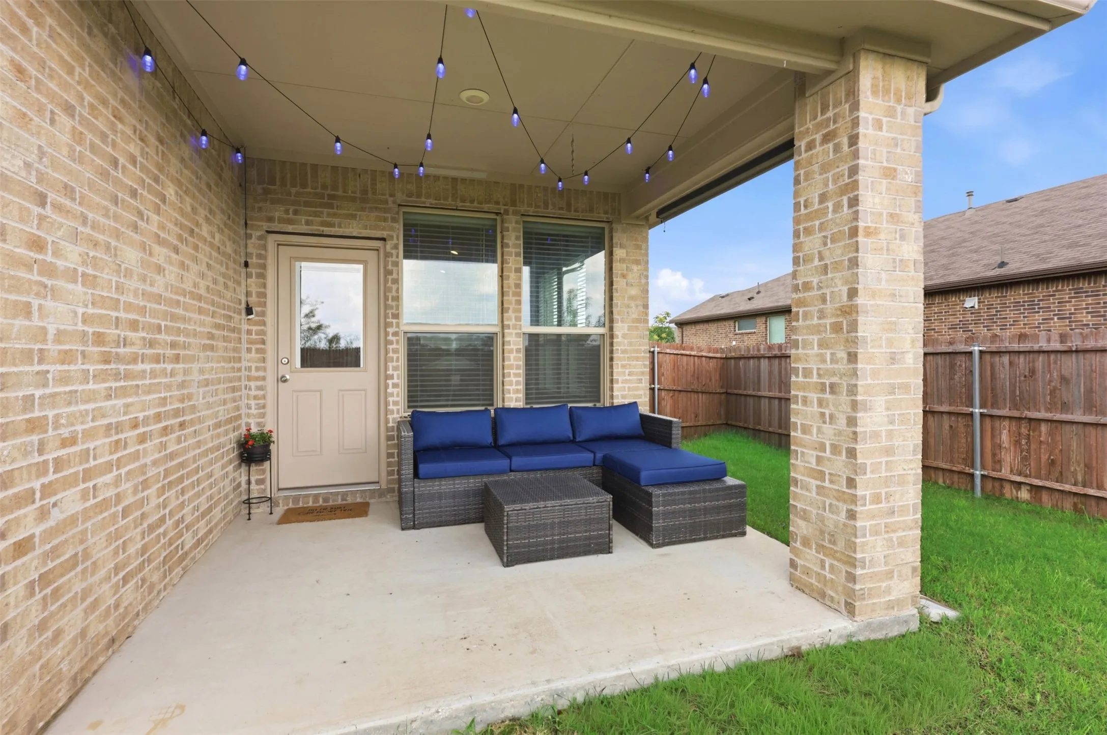Covered patio featuring a concrete slab and string lighting