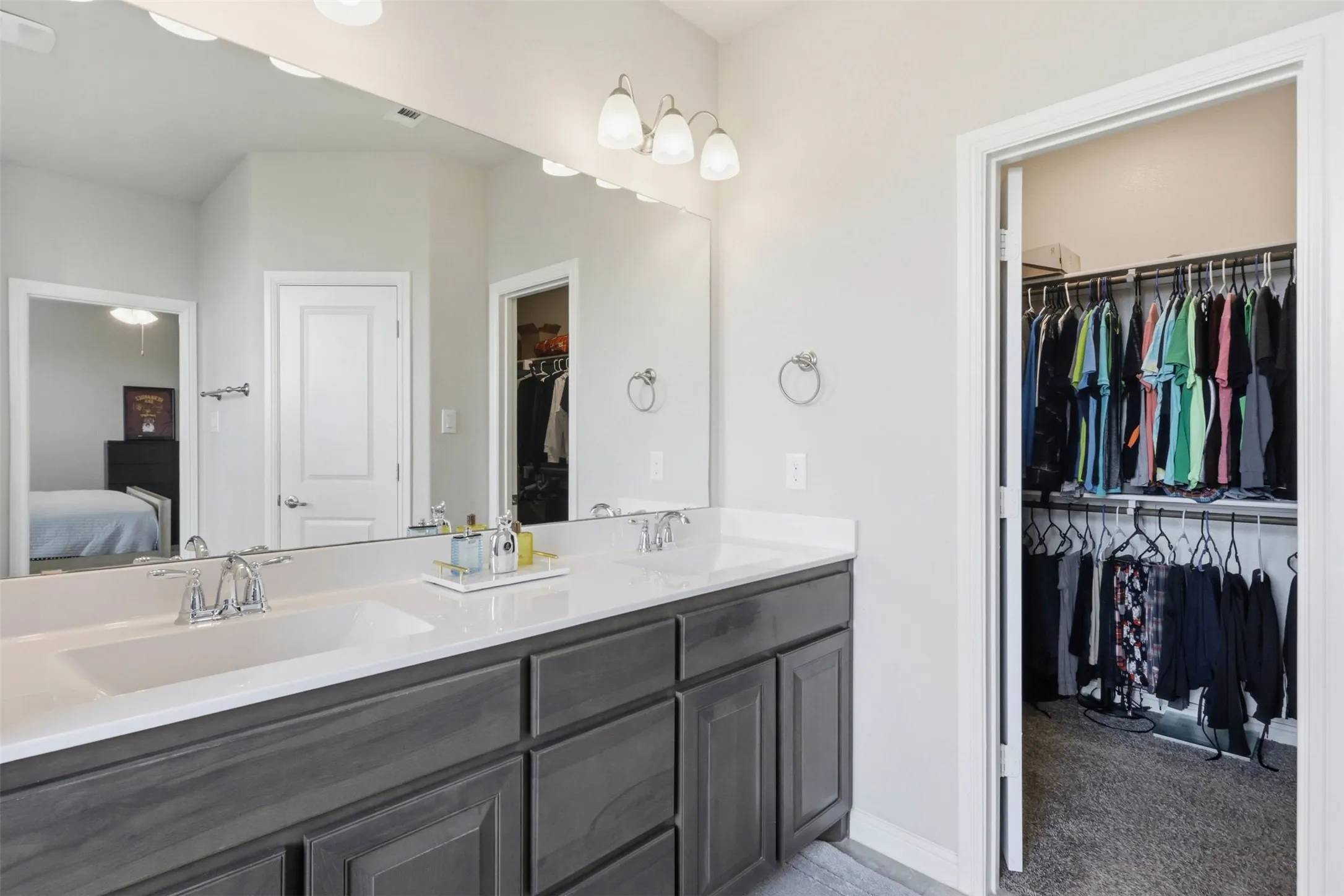 Dual vanity with a white countertop and undermount sinks, set within a dark wood-finish cabinet