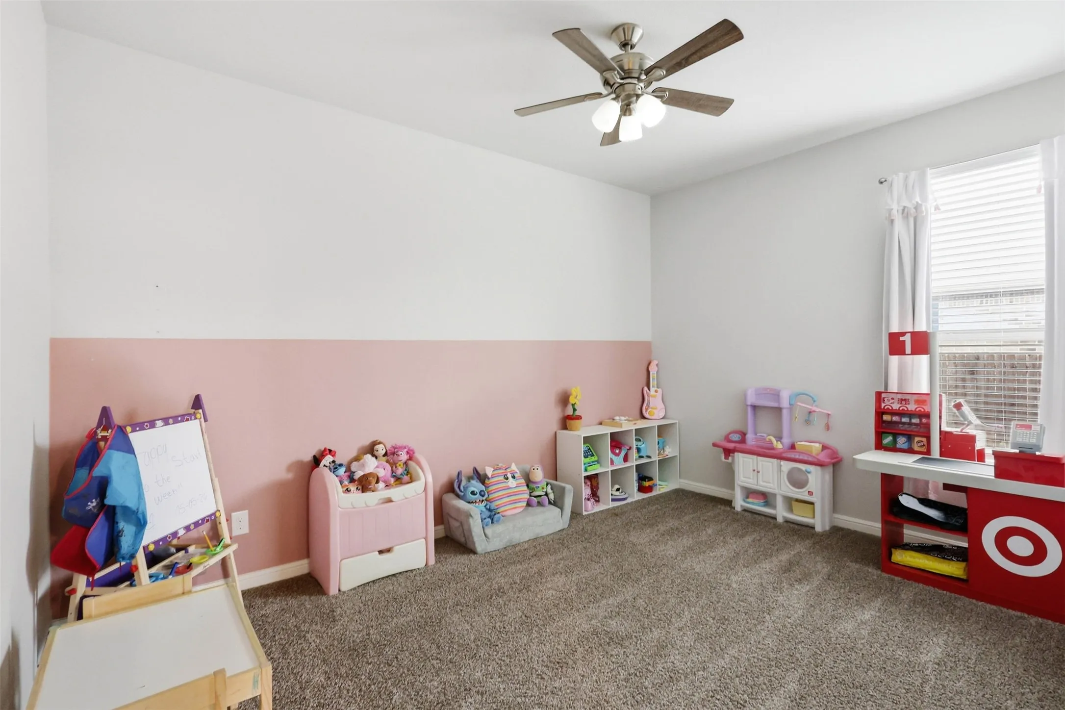 Carpeted room with a ceiling fan light fixture