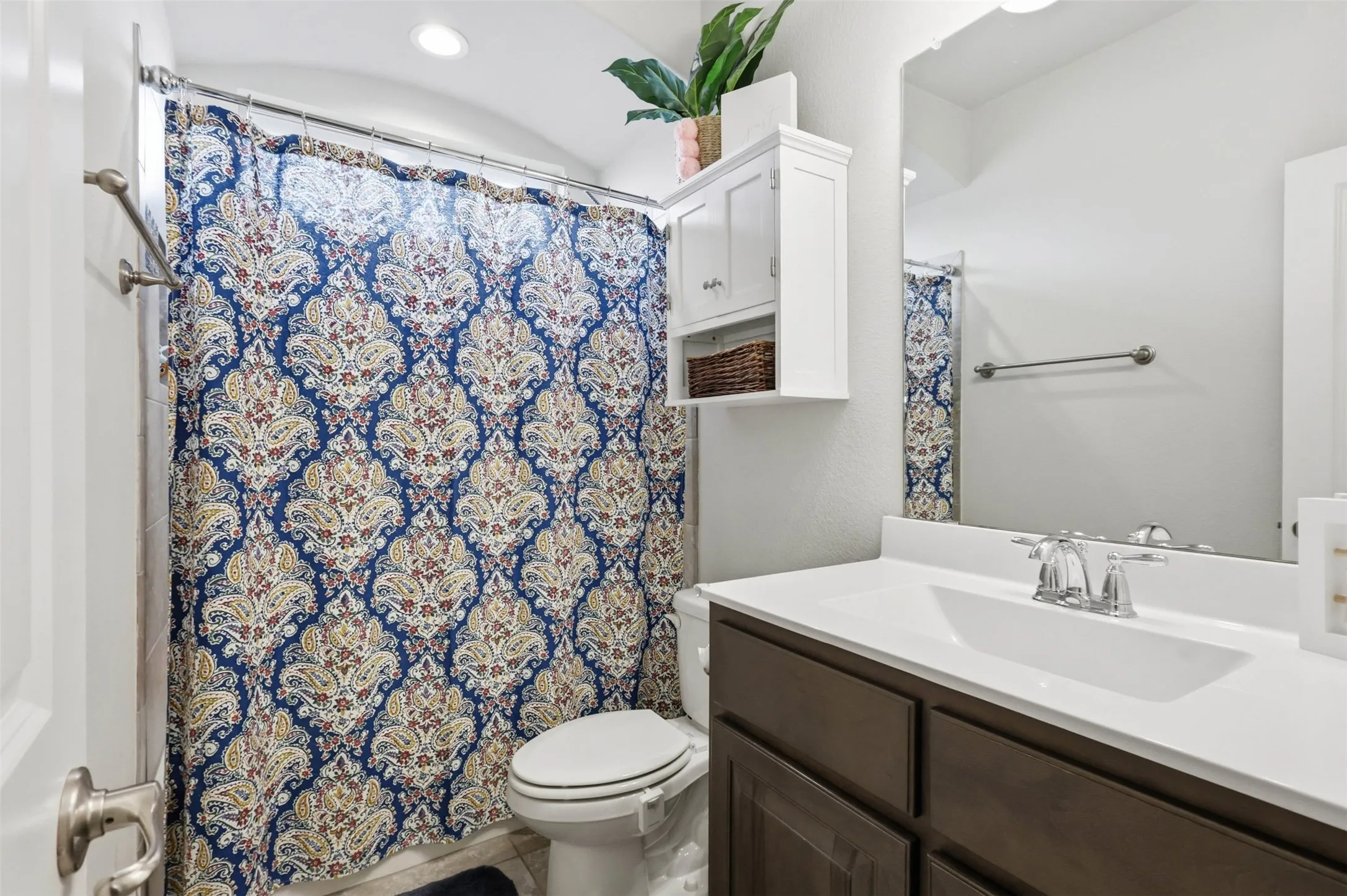 Full bathroom featuring a single vanity with a white countertop and dark wood-finish cabinetry