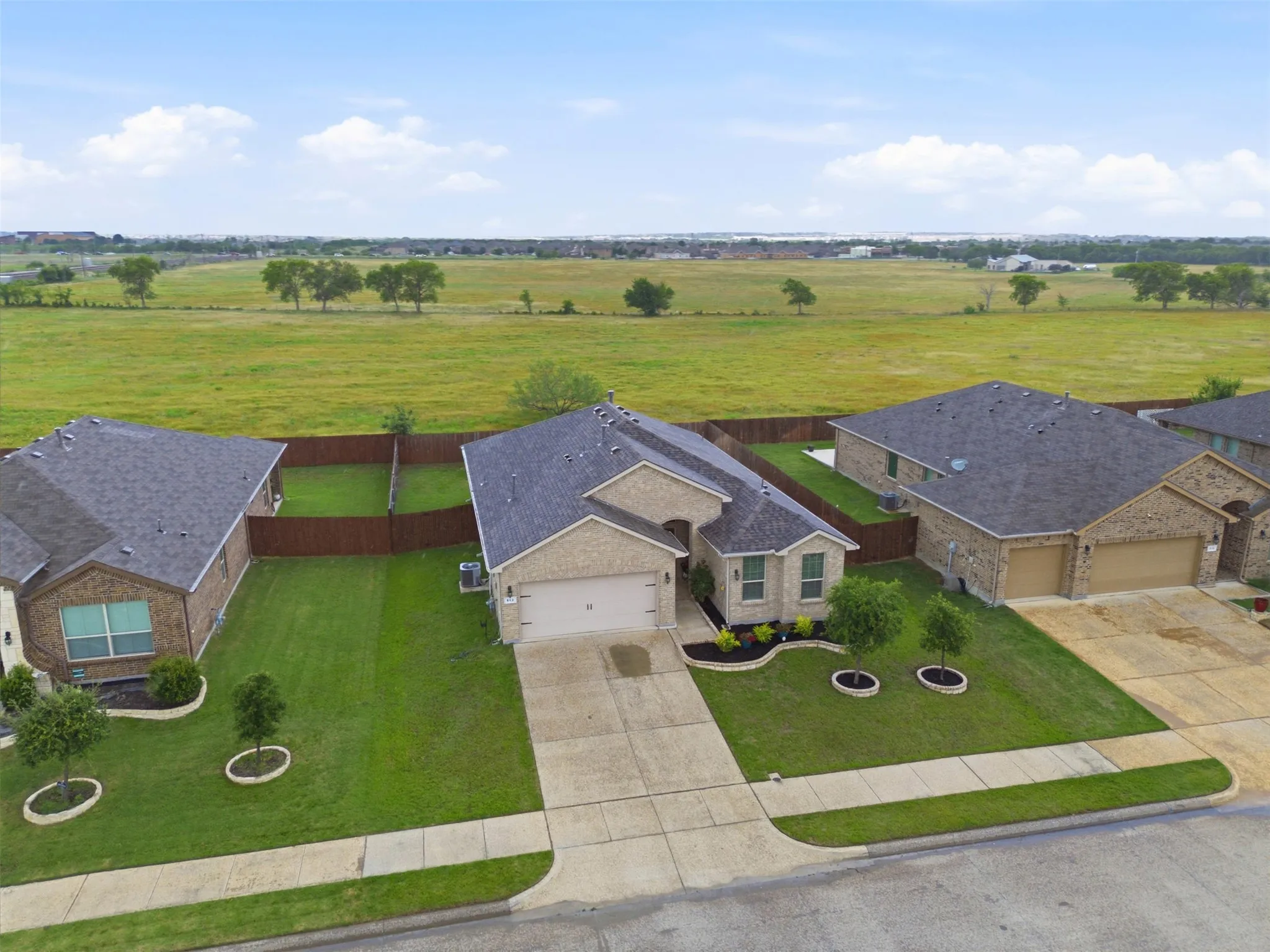 Brick exterior residence featuring a gray shingle roof and a two-car garage
