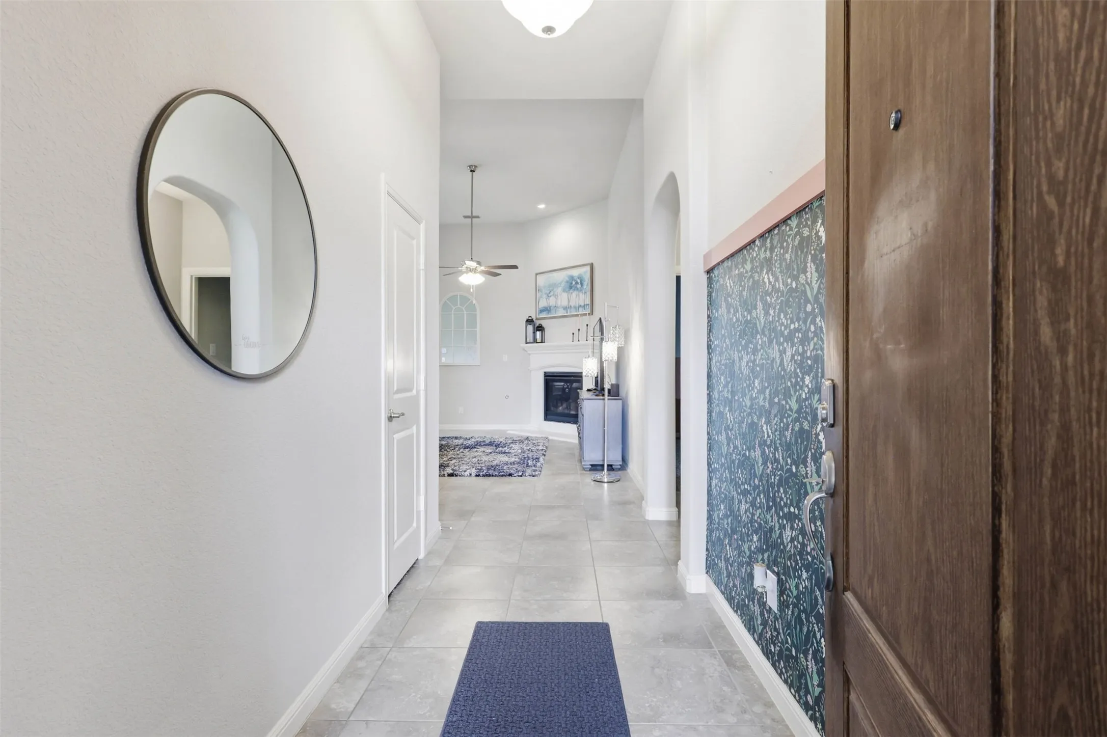Entryway featuring wood-finish door, patterned wall paneling, and tile flooring