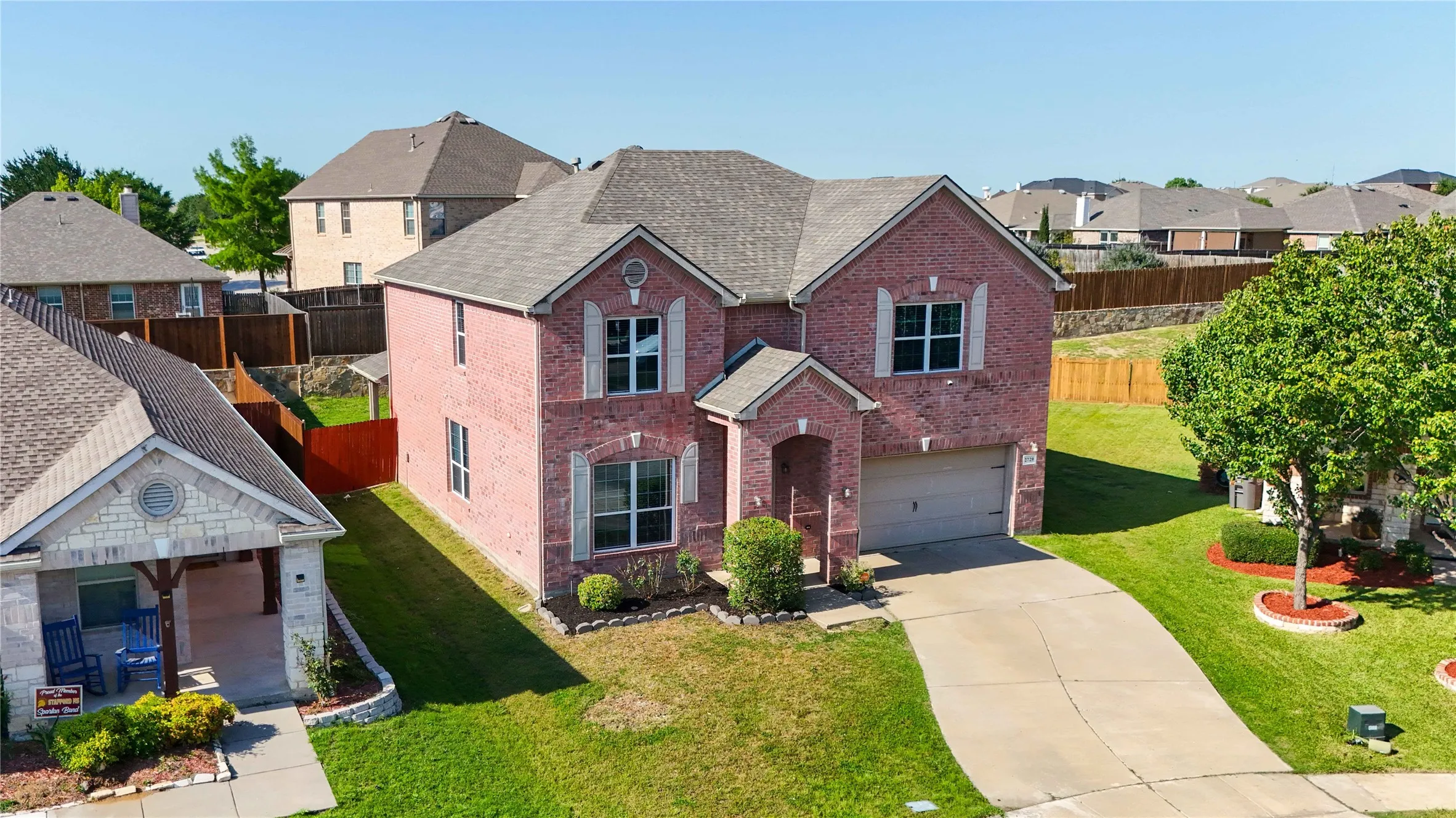 Two-story brick facade residence featuring a front-facing attached garage and a concrete driveway