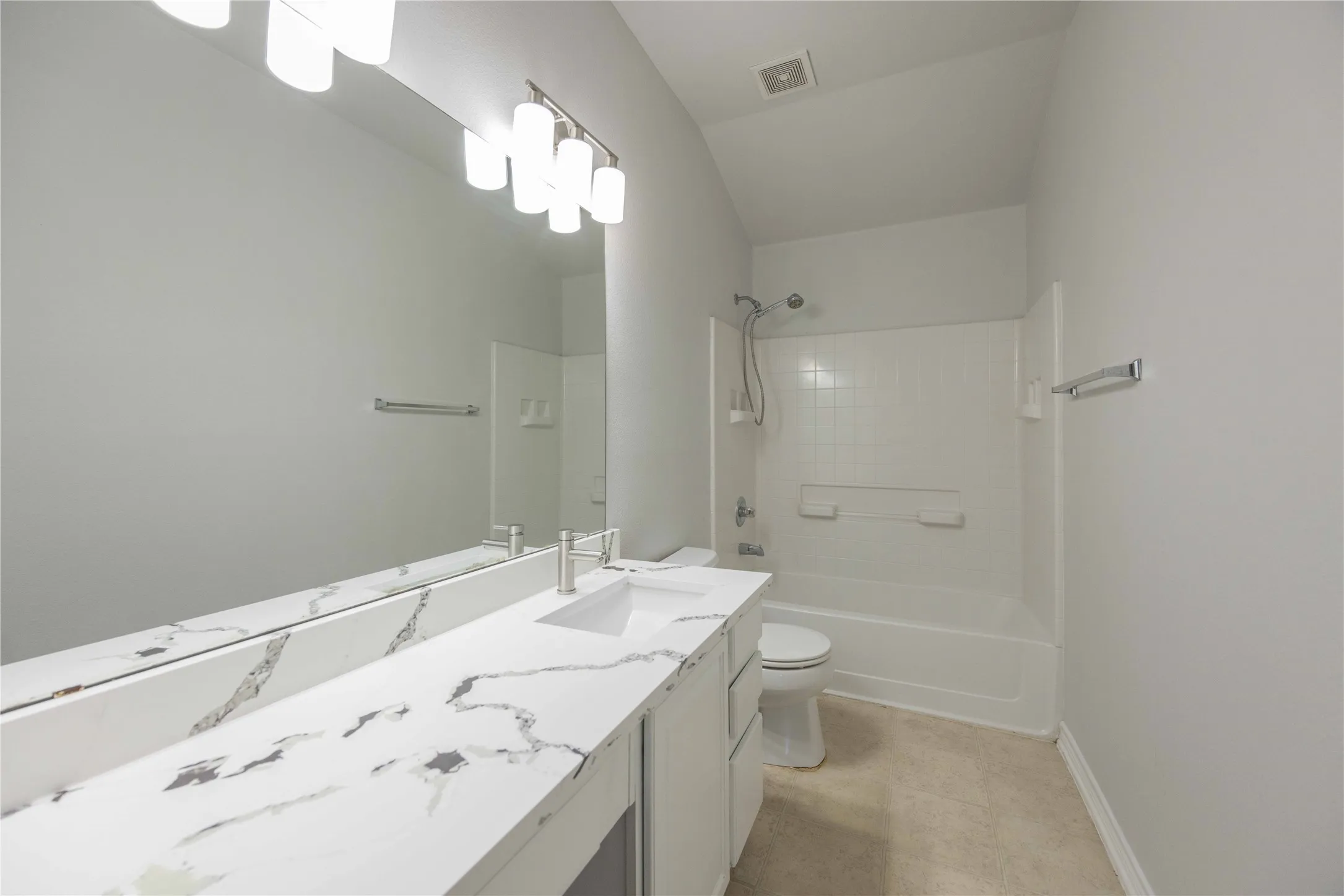 Spacious bathroom featuring a double vanity with a marble-finish countertop, integrated rectangular sink, and chrome fixtures