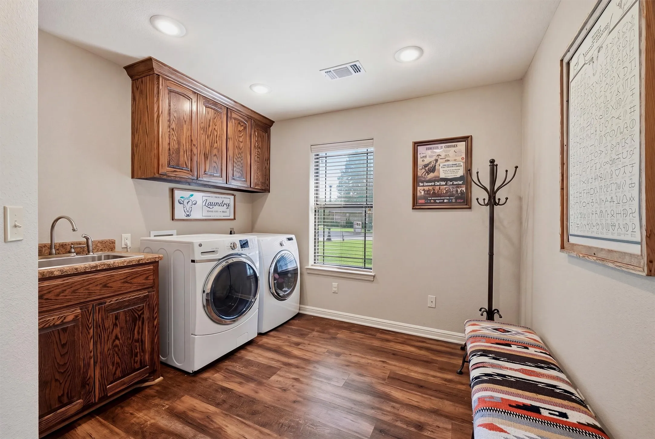 Laundry room featuring wood-finish flooring, built-in cabinetry, a utility sink with a stone-finish countertop, and recessed lighting