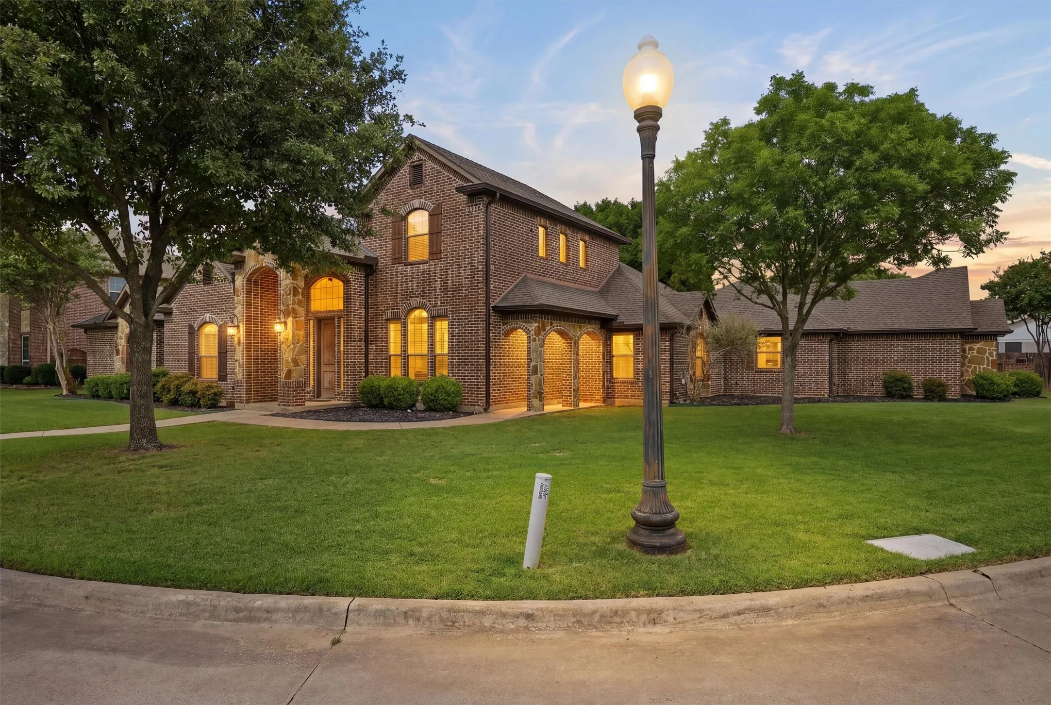 Brick-clad residence featuring multiple arched entryways and an arched front door
