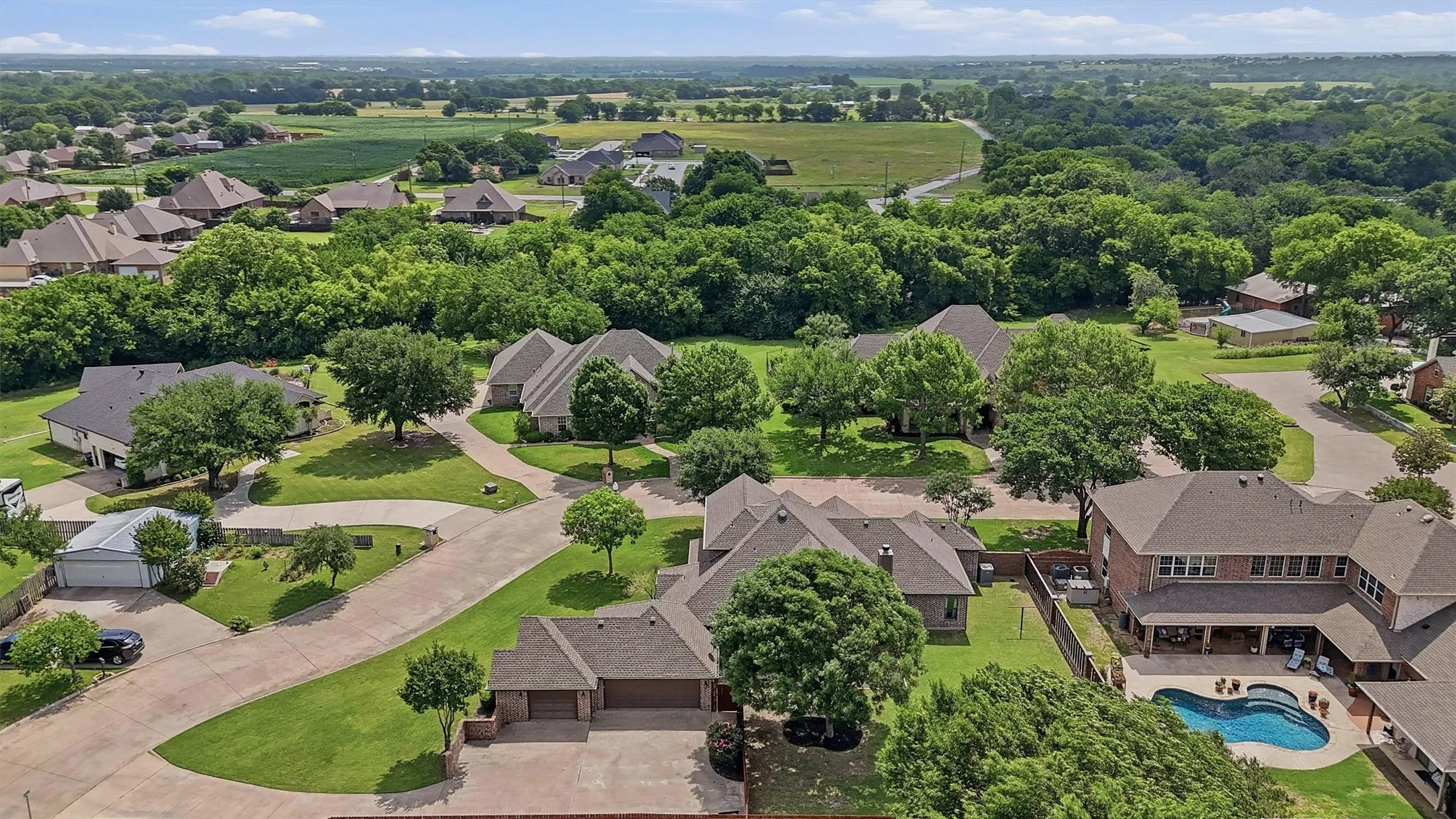 Aerial perspective showcasing a residential community with abundant mature trees and verdant landscaping
