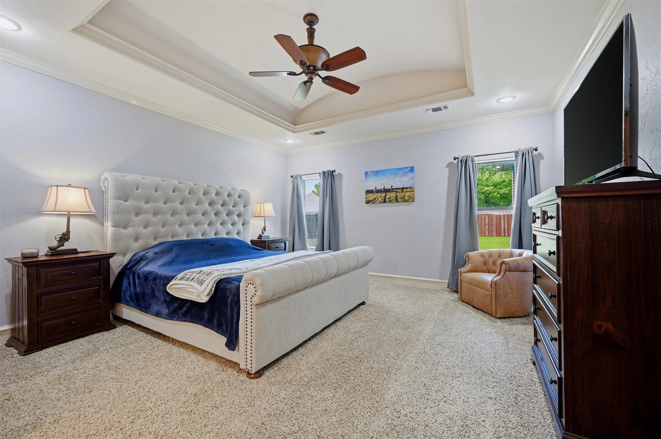 Spacious room featuring a tray ceiling, crown molding, a ceiling fan, recessed lighting, and carpet flooring