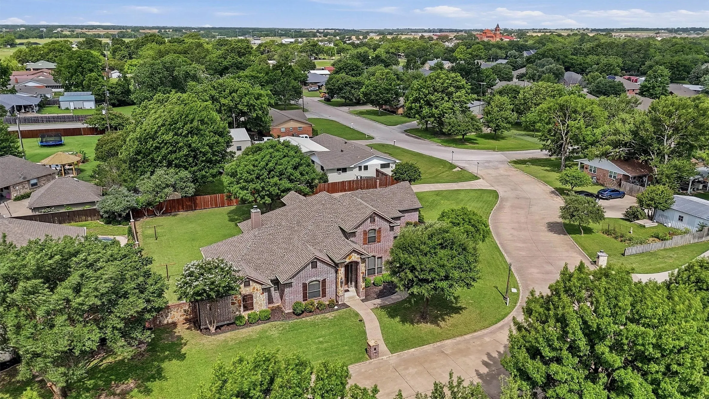 Spacious property featuring a brick and stone facade, a multi-gabled roofline, and established landscaping