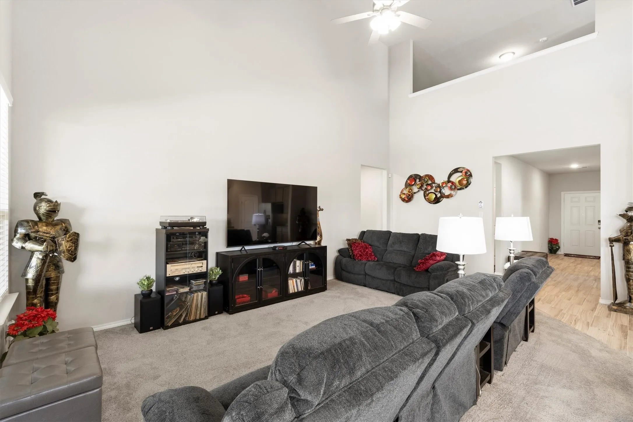 Expansive living area featuring soaring ceilings and a ceiling fan with integrated lighting