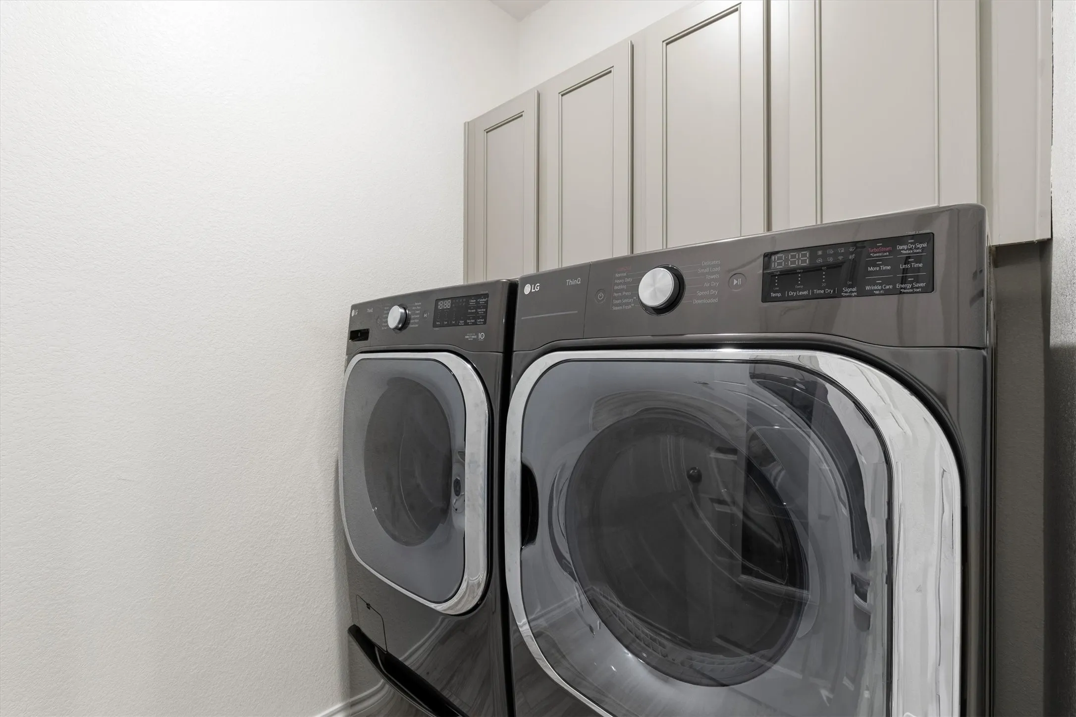 Dedicated laundry area featuring a front-loading washer and dryer set
