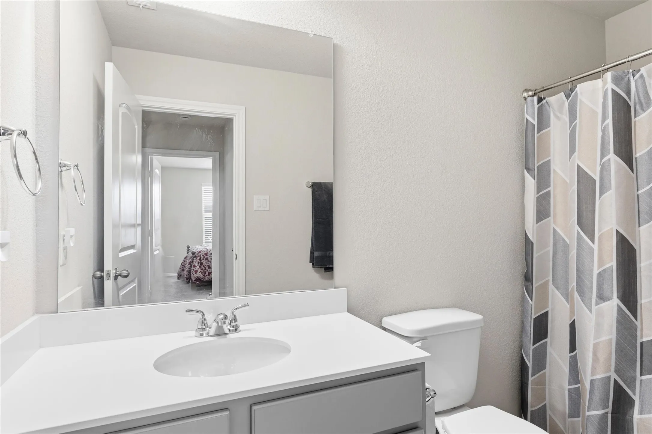 Bathroom vanity featuring a light countertop with an integrated sink and a chrome faucet