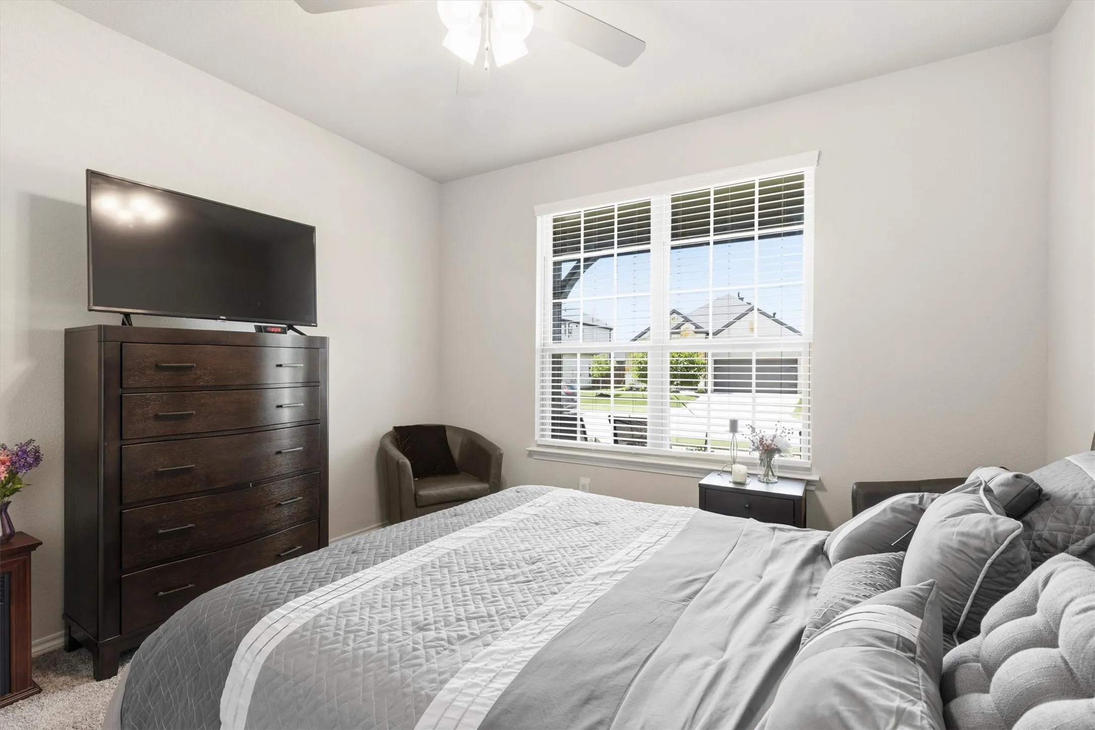 Bedroom featuring light-colored walls, a ceiling fan with light fixture, and carpeted flooring
