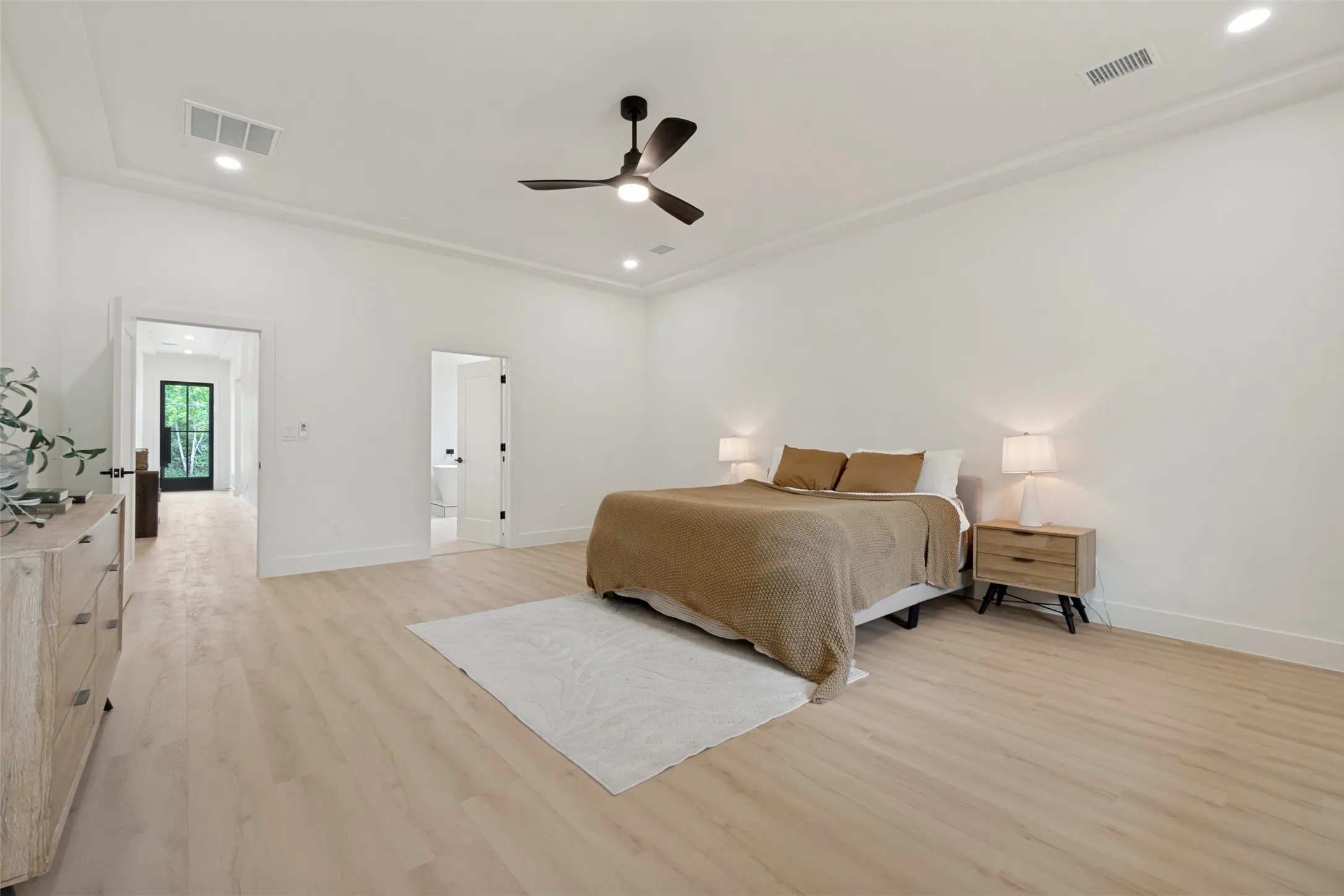 Spacious room featuring light wood-finish flooring, recessed lighting, and a contemporary ceiling fan