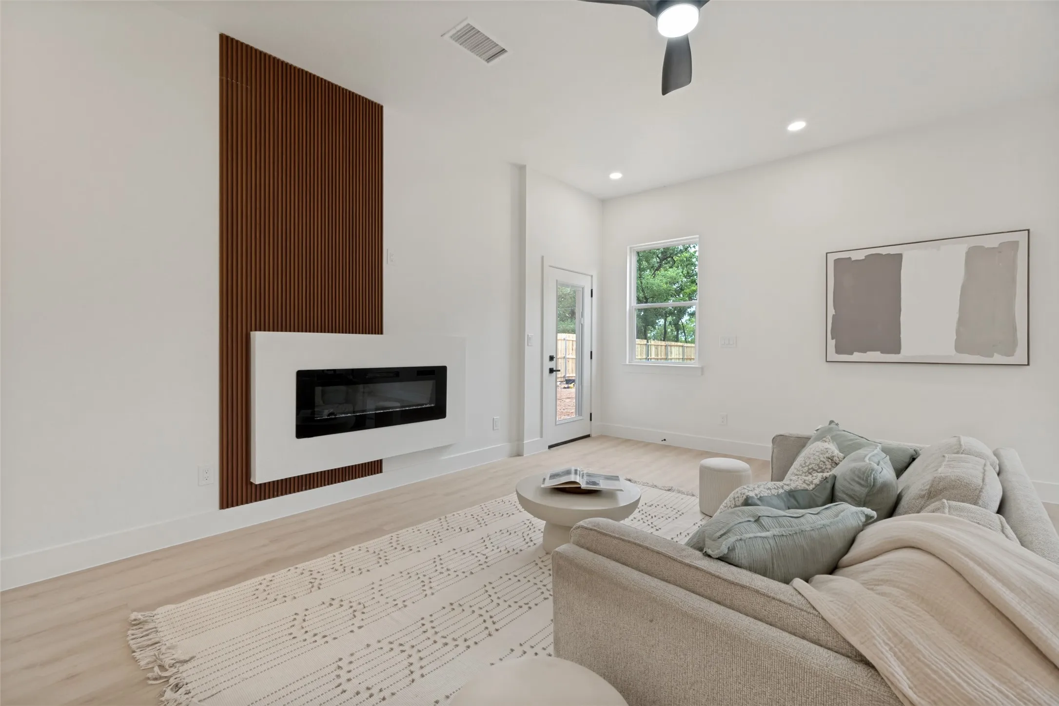 Living space featuring a modern wall-mounted fireplace with a wood slat accent wall