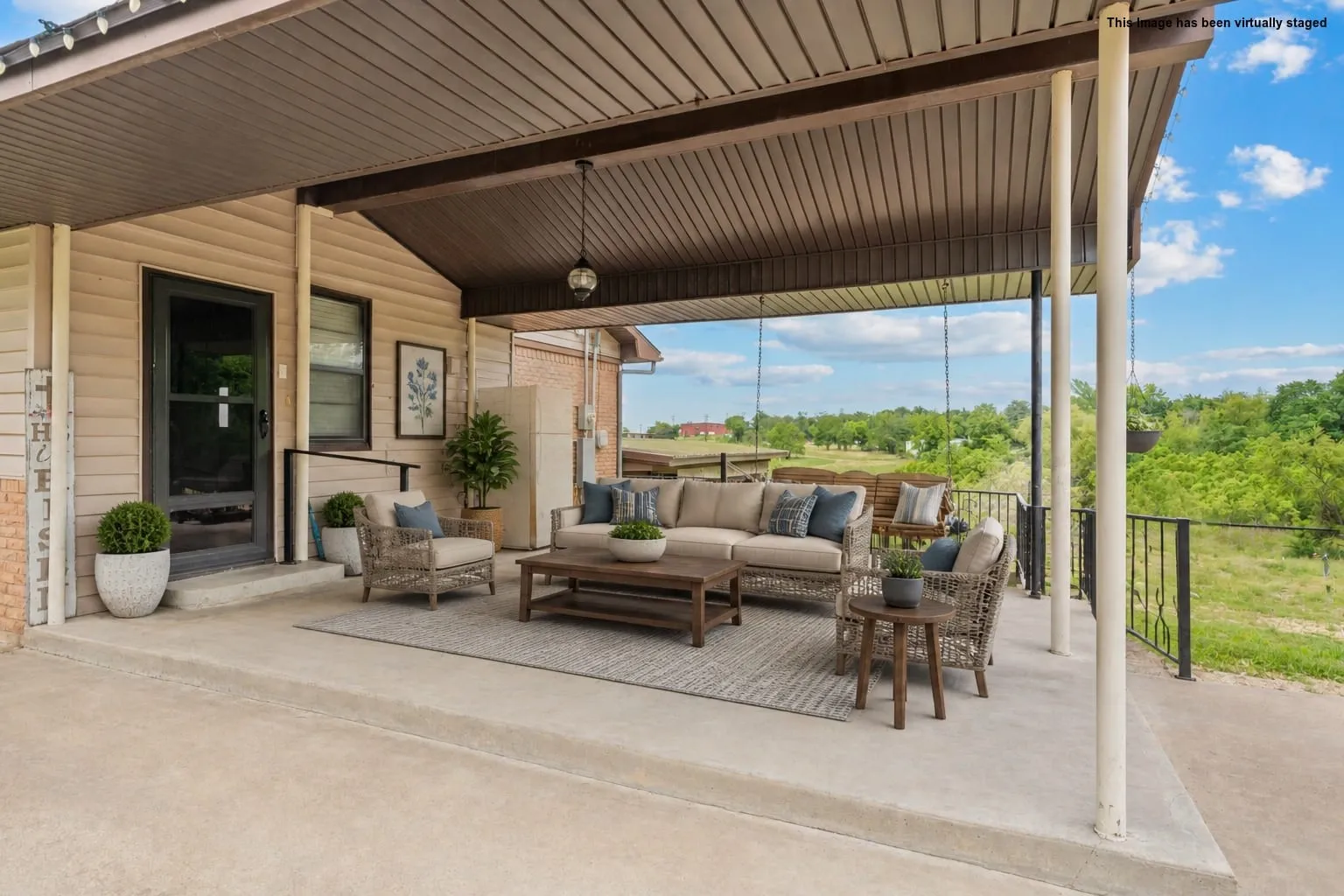Expansive covered patio featuring a concrete surface, black metal railing, and a slatted brown ceiling