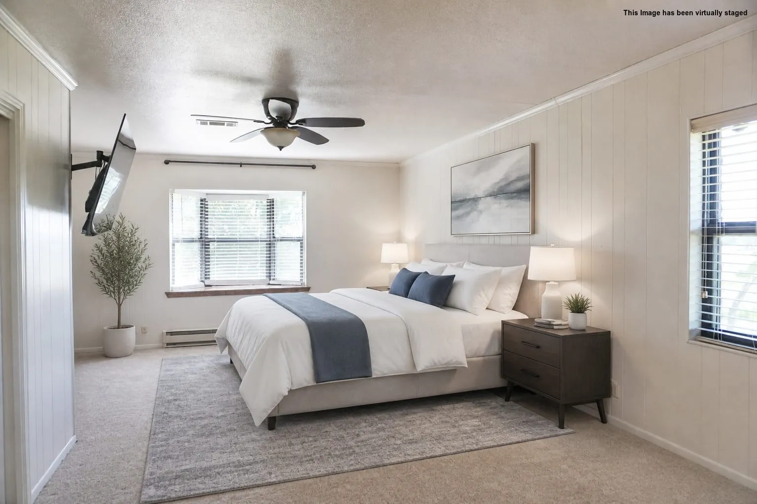 Carpeted bedroom featuring a ceiling fan, a window with blinds, and white vertical wall paneling