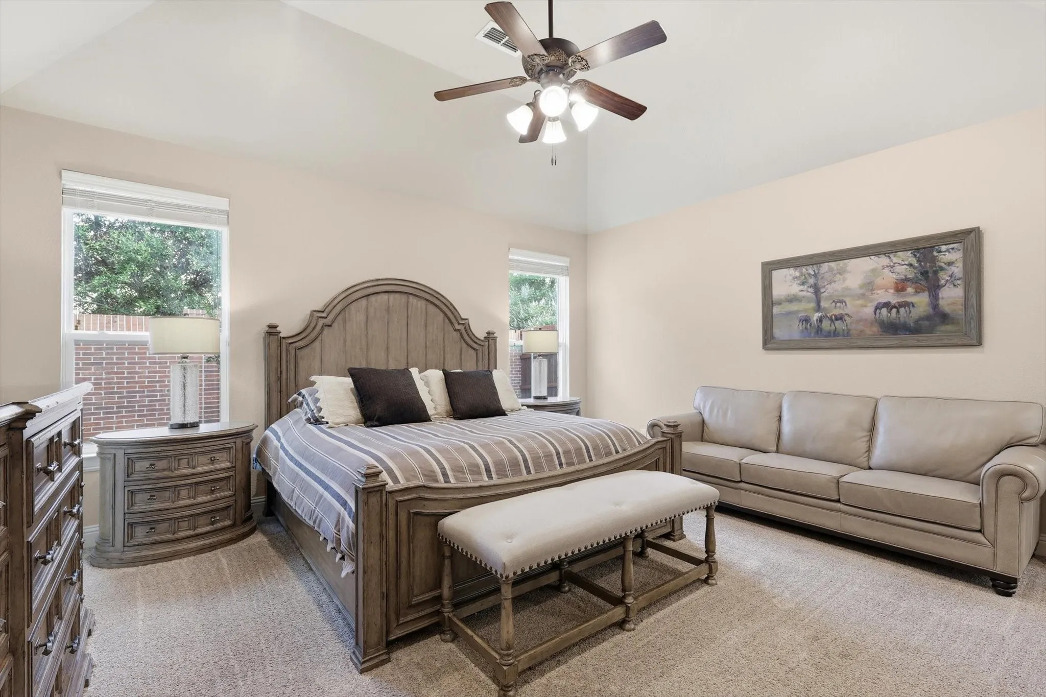 Carpeted room featuring a vaulted ceiling with a ceiling fan