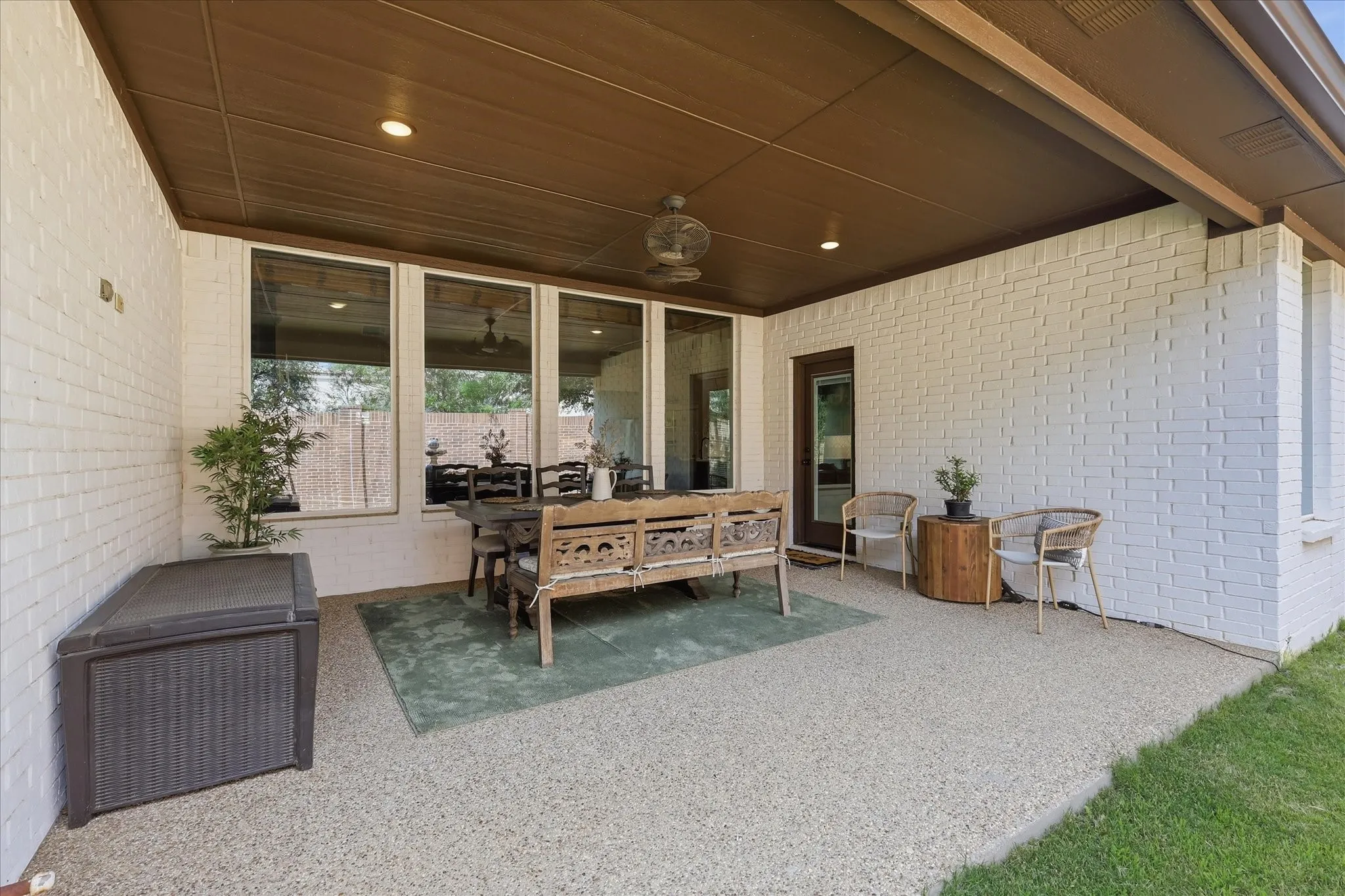 Covered patio with a painted brick exterior and aggregate flooring