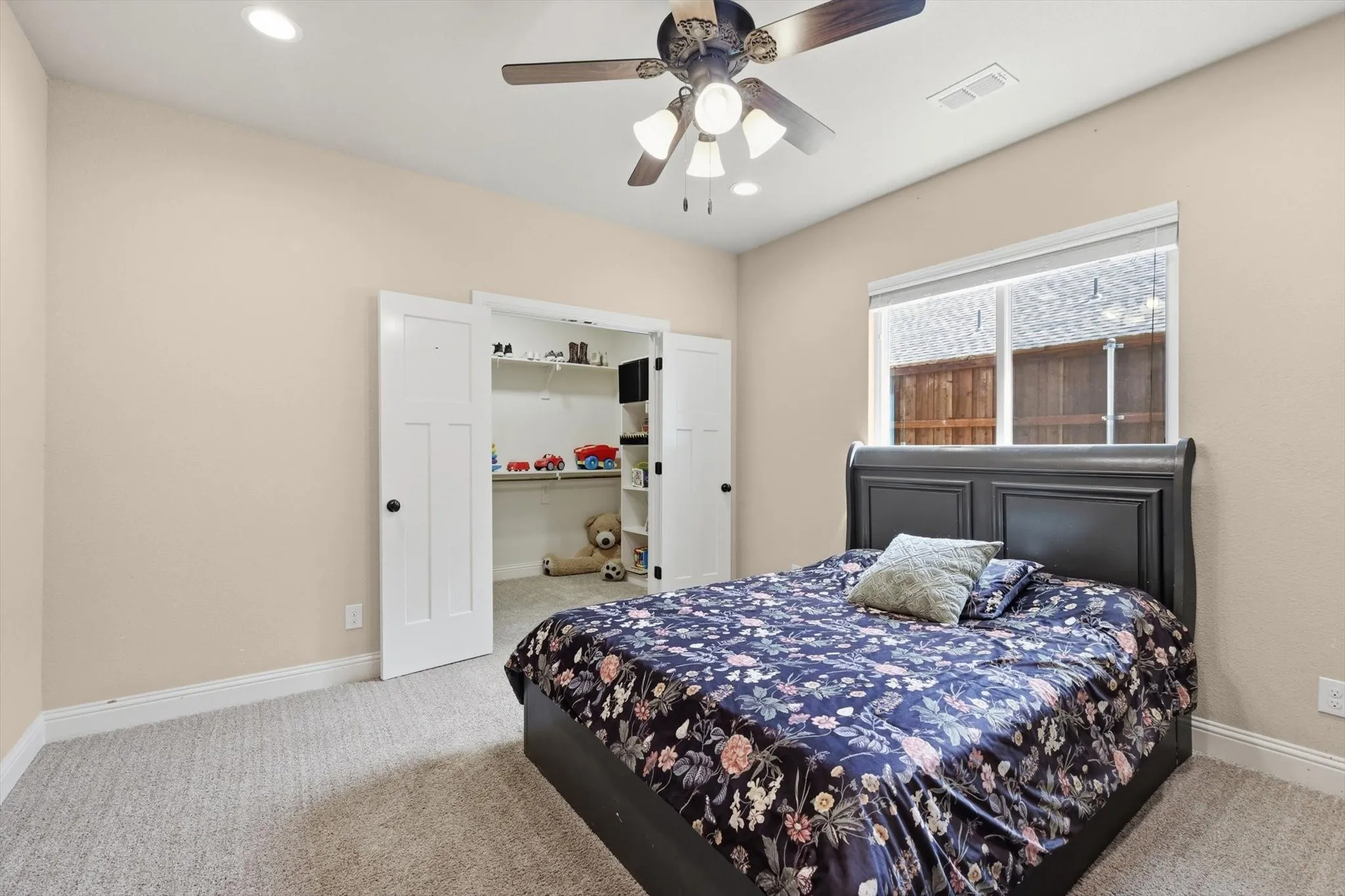 Spacious room featuring neutral wall paint and light-colored carpeting