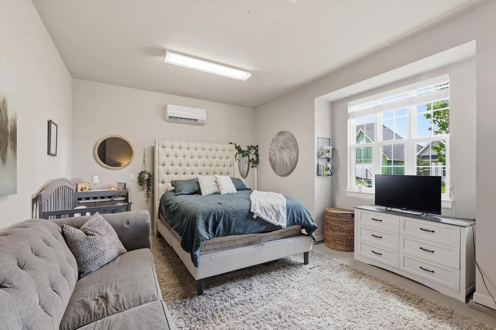 Spacious room featuring a large window with white blinds, light neutral wall paint, and recessed lighting