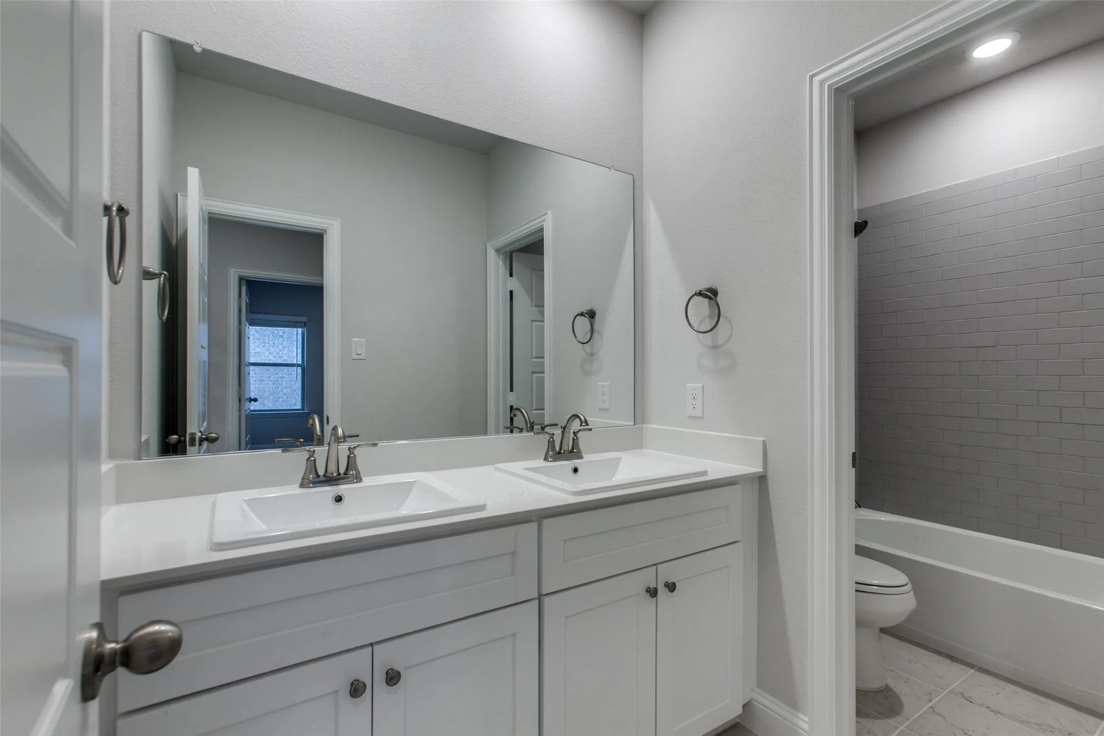Double vanity featuring white cabinetry, integrated sinks, and polished chrome faucets