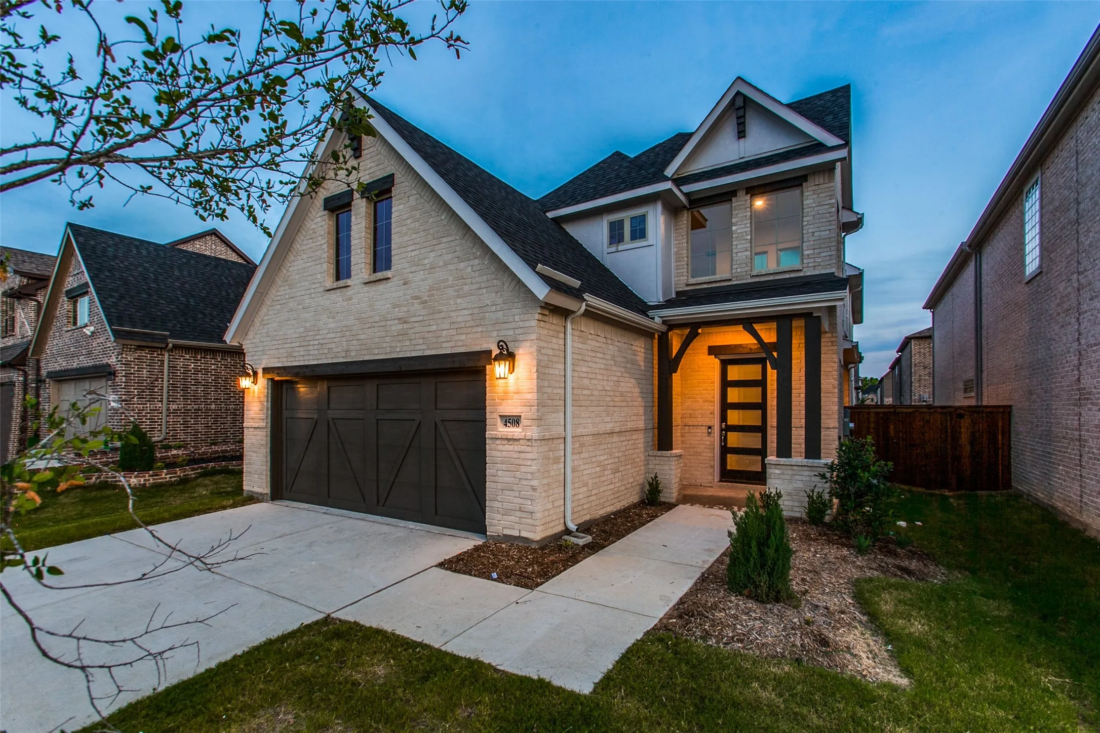 Contemporary two-story residence featuring light brick masonry and dark trim accents