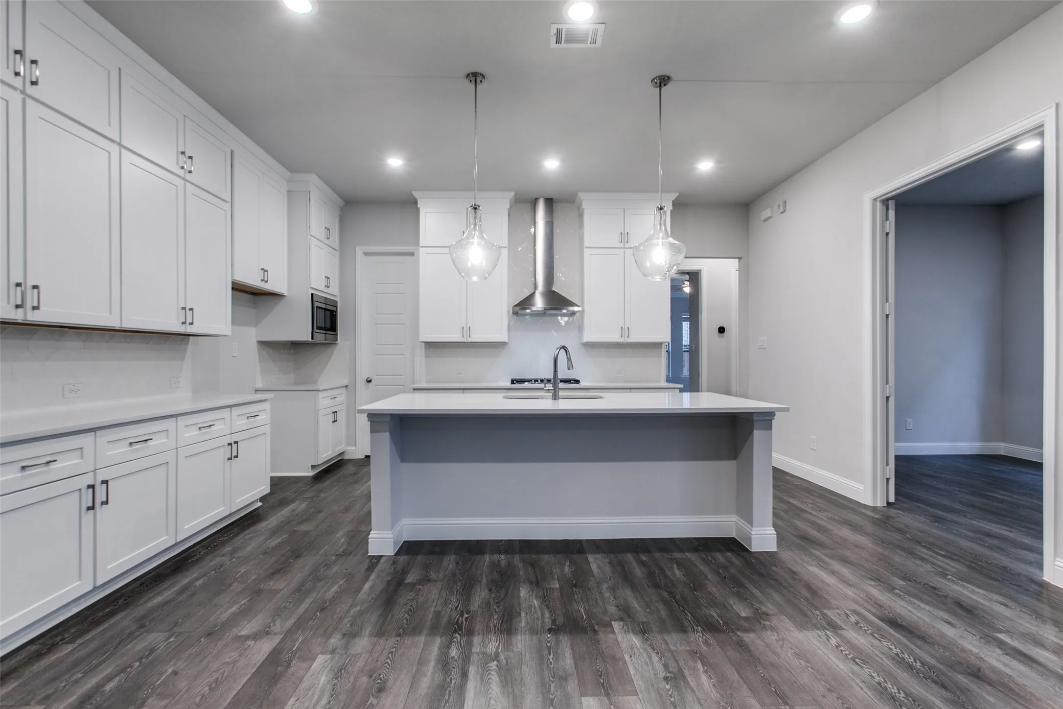 Kitchen featuring an expansive center island with an undermount sink and gooseneck faucet