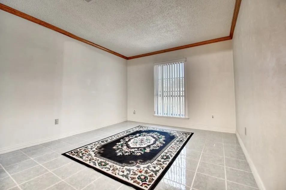 Ceramic tile flooring, crown molding, and a window with vertical blinds
