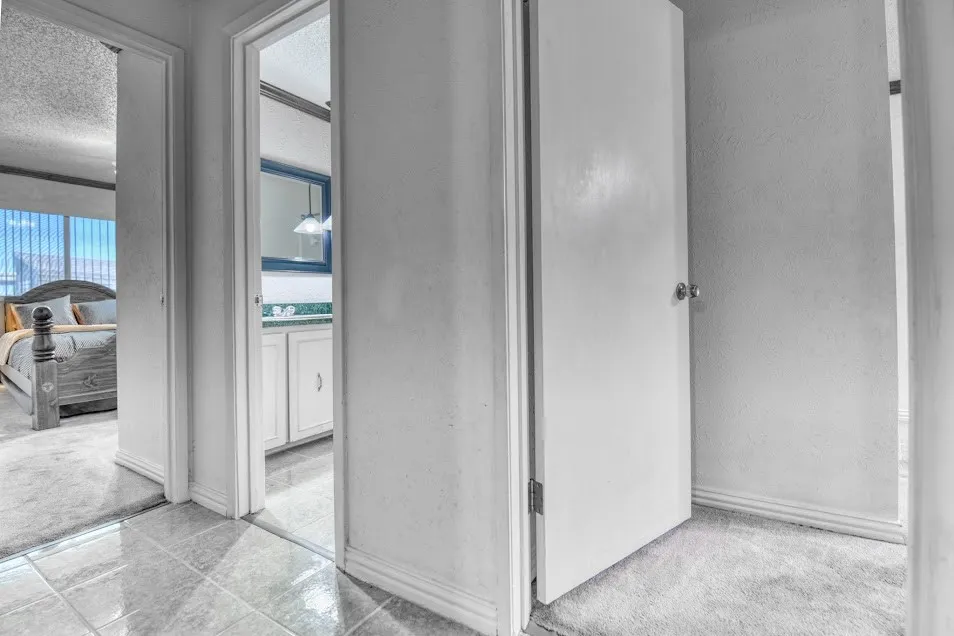 Tile flooring, carpeted room, white painted walls, white doors, white trim