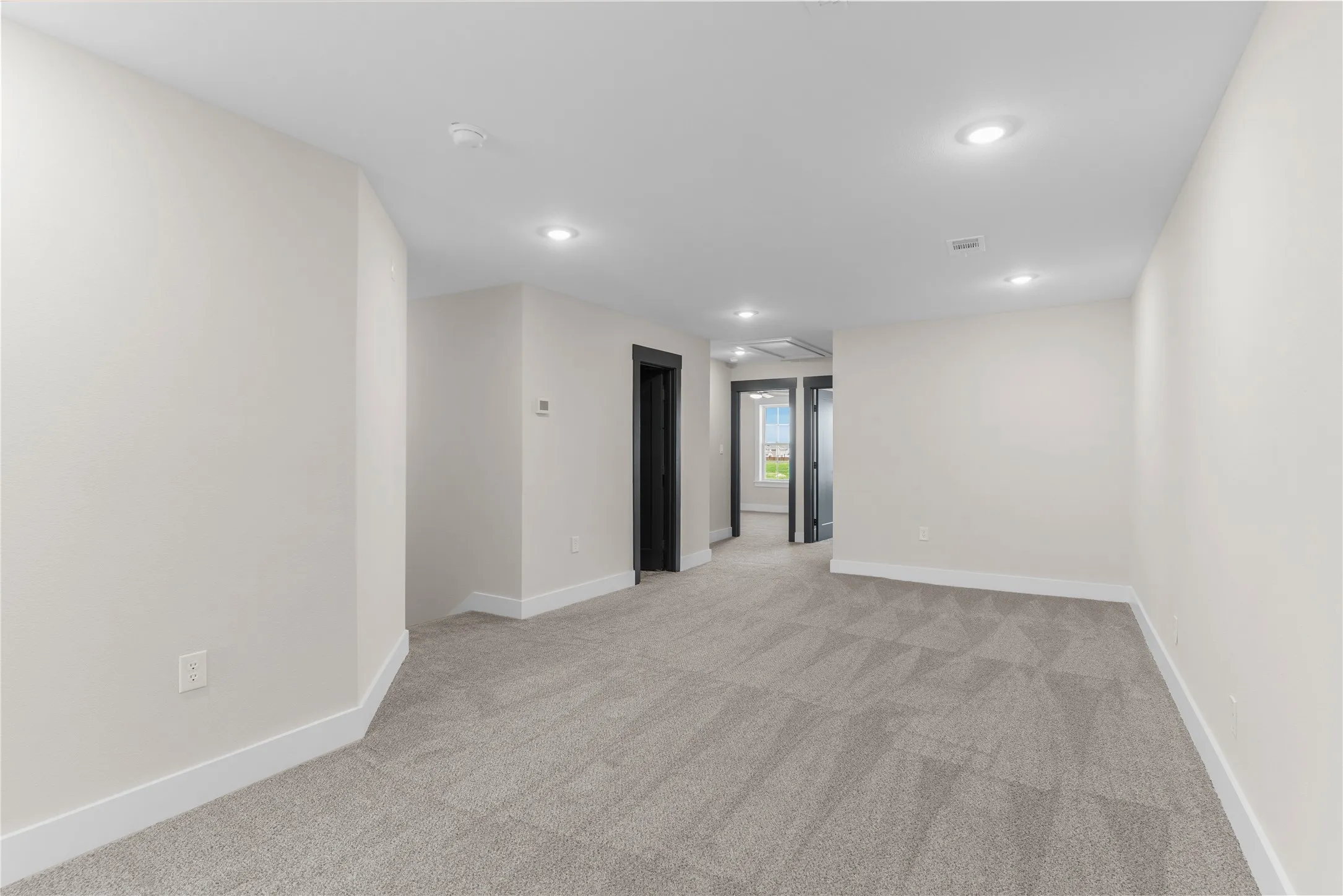 Carpeted interior space with recessed lighting and neutral wall tones