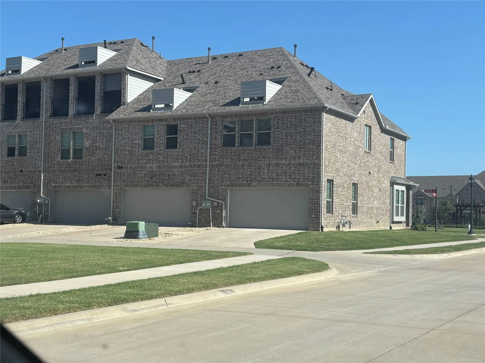 Brick exterior featuring a multi-level roofline, double-pane windows, and an attached two-car garage