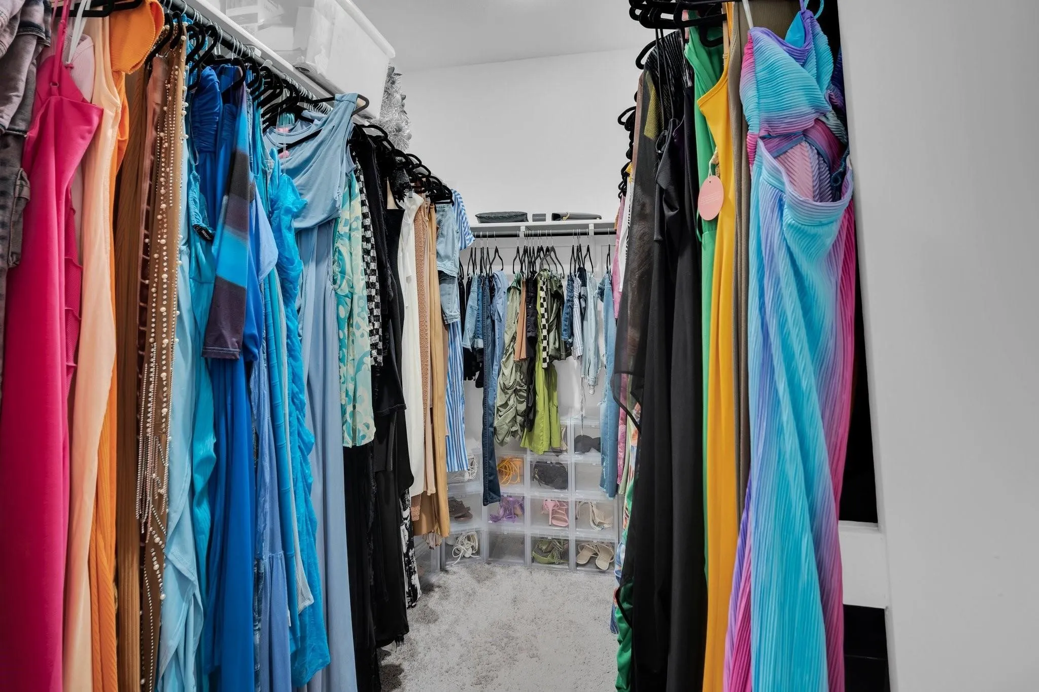 Walk-in closet featuring built-in hanging rods, upper shelving, and recessed lighting