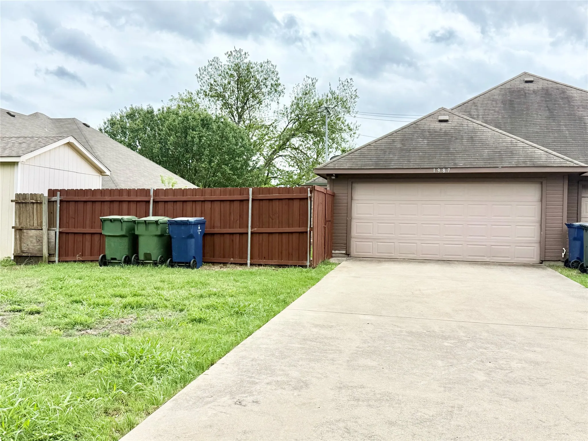 Concrete driveway leading to a two-car garage with a panel door