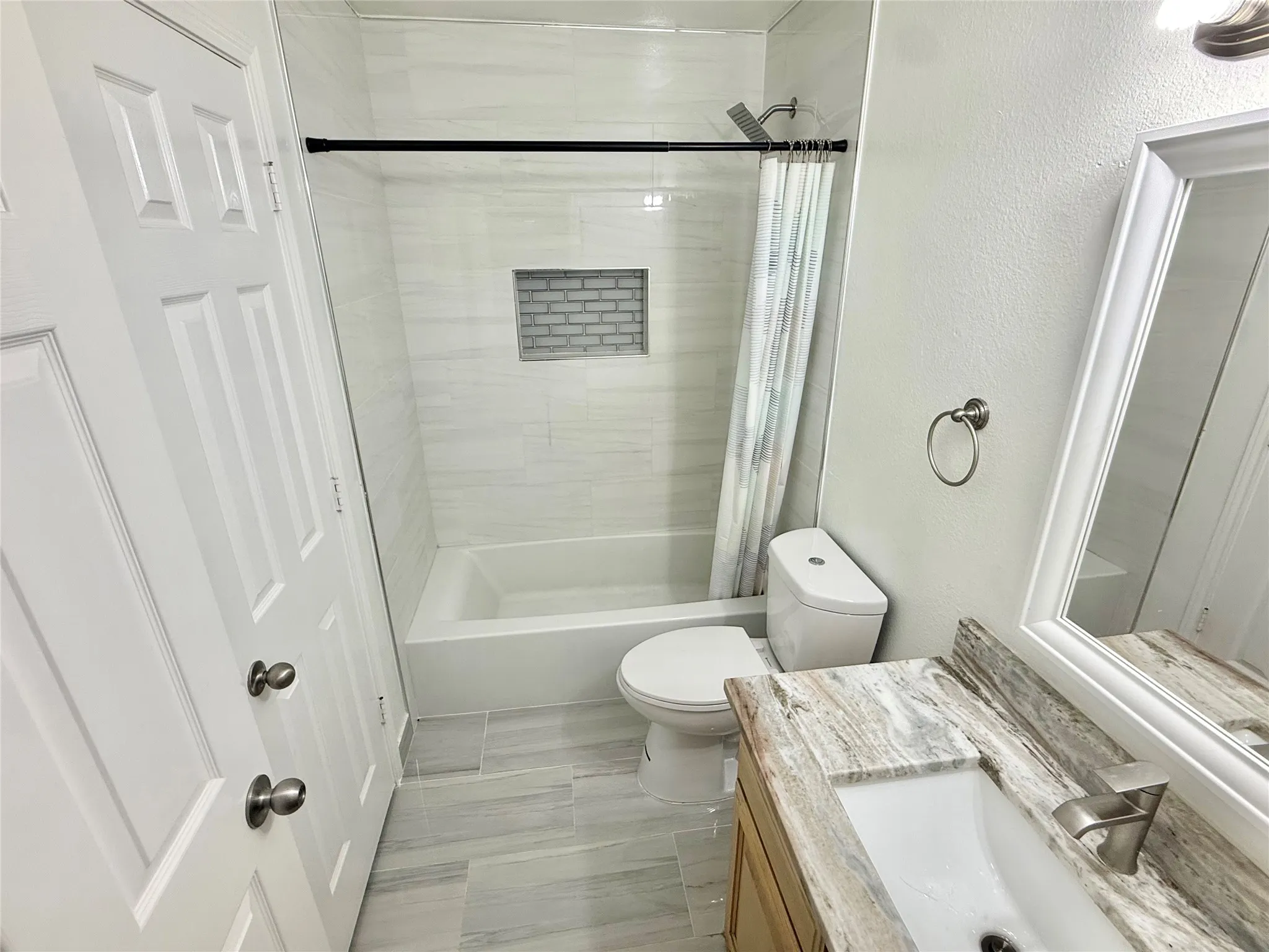 Bathroom featuring a vanity with a stone countertop, a white rectangular sink, and a brushed nickel faucet
