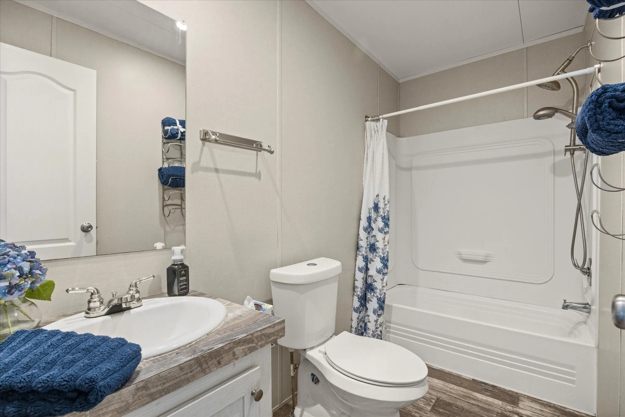 Bathroom featuring a white vanity with an oval basin, chrome faucet, and wood-finish countertop