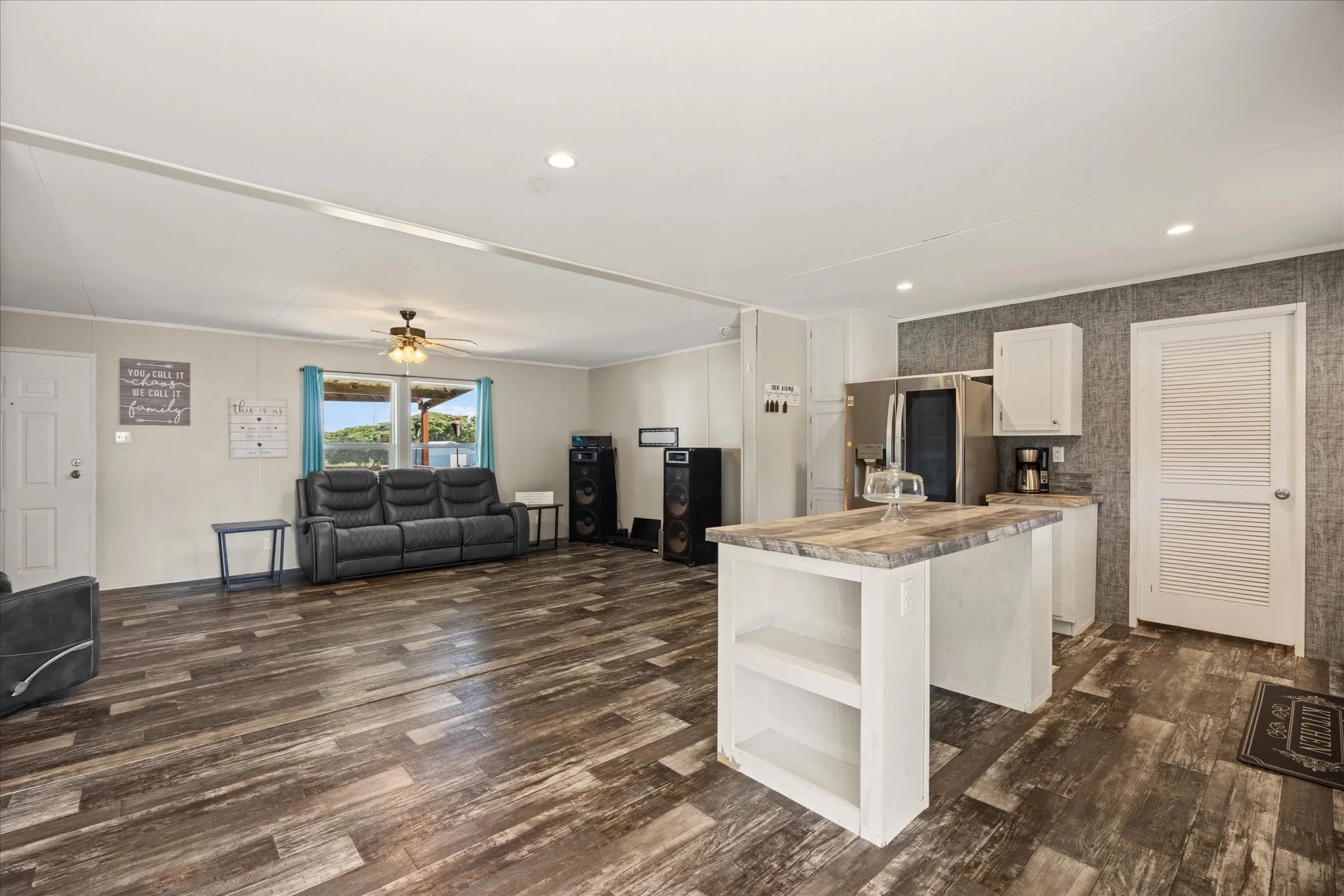 Spacious open-concept living area featuring wood-finish flooring, recessed lighting, and a ceiling fan