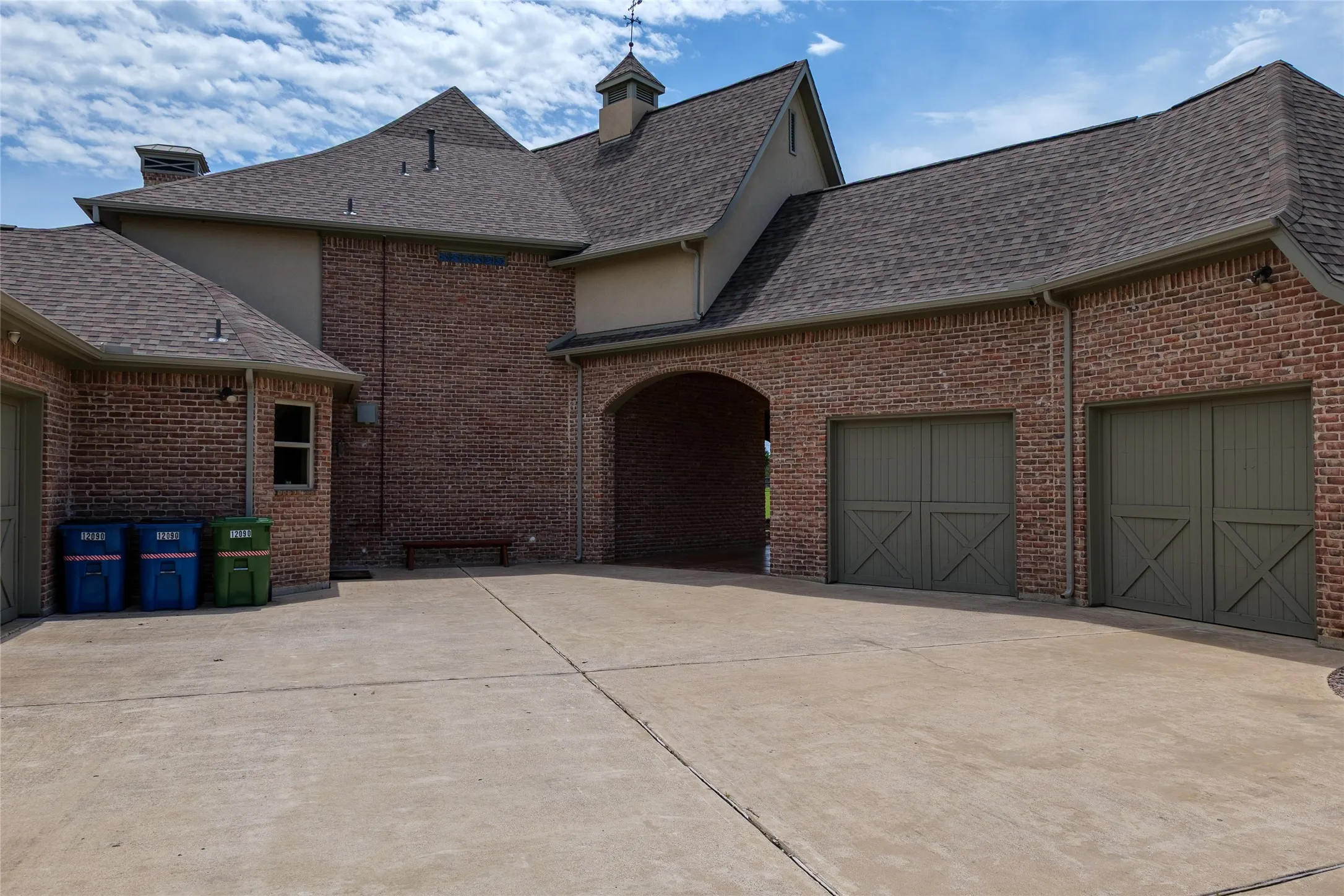 View of two-car garage with porte cochère and driveway