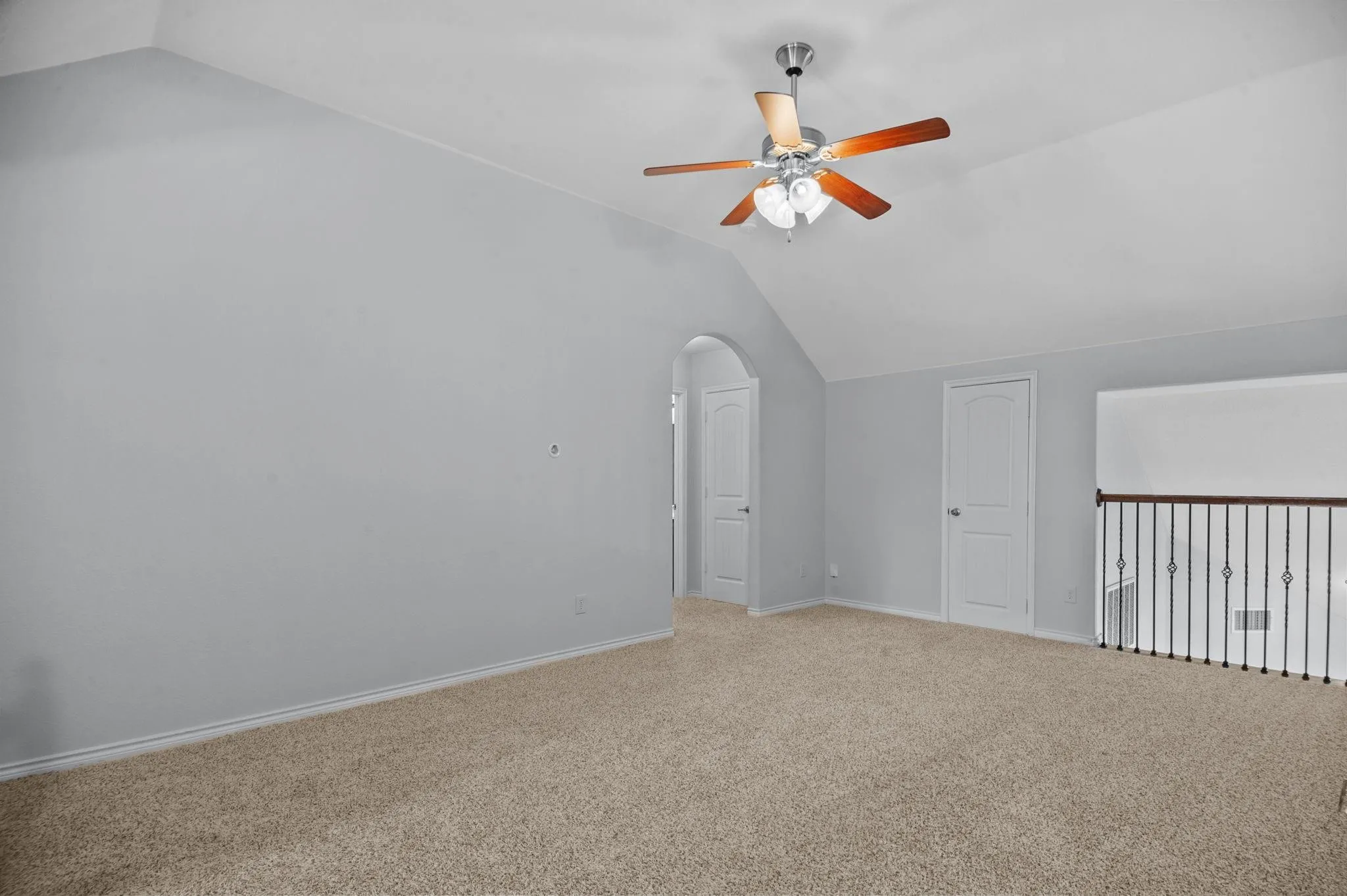 Gameroom with ceiling fan and railing.
