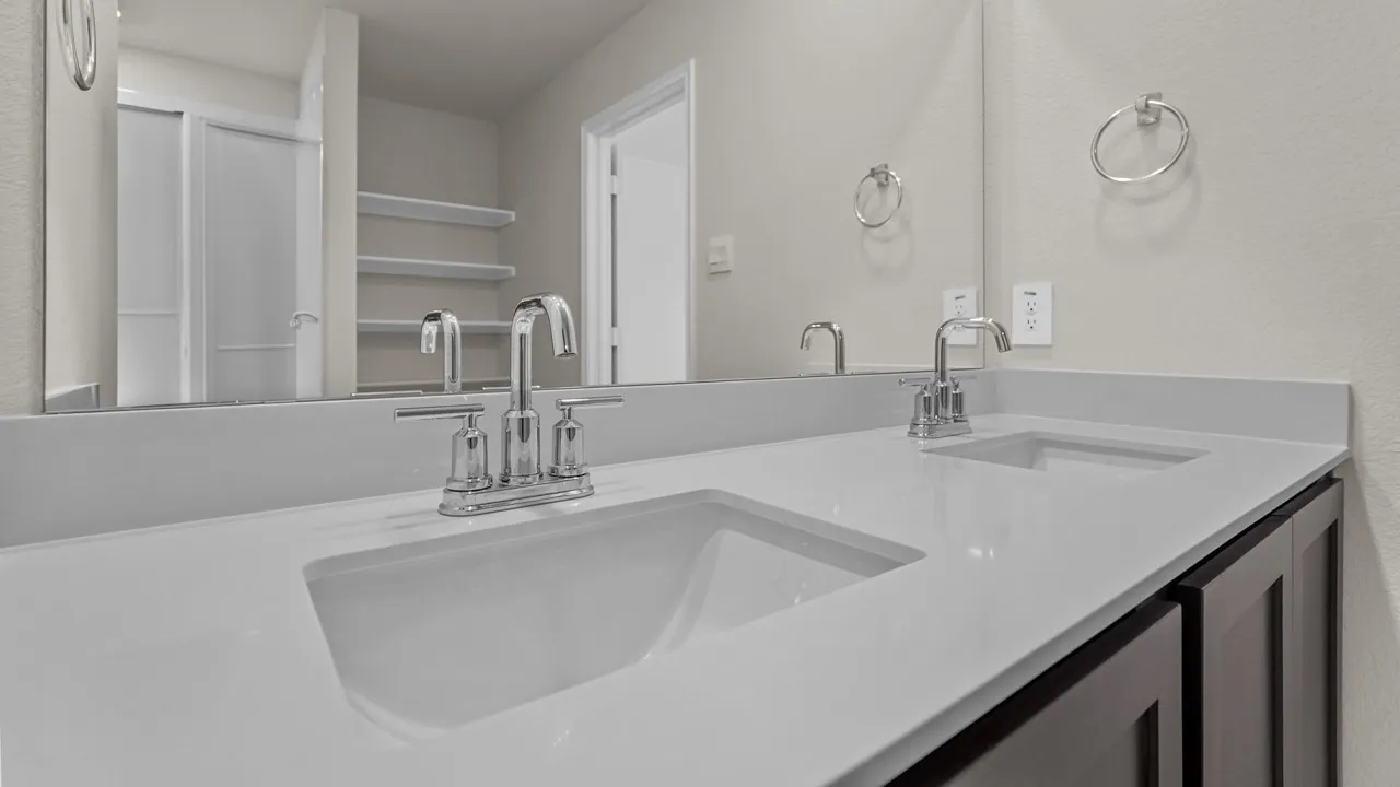 Dual undermount sinks with chrome fixtures set into a light-toned countertop