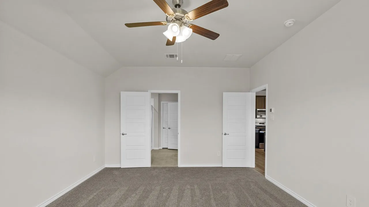 Spacious room featuring vaulted ceilings and neutral-toned carpeting