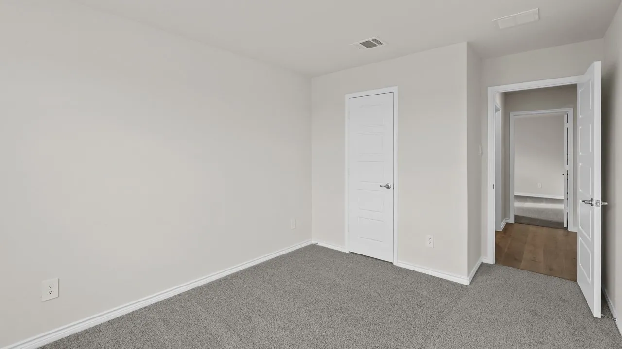 Carpeted room with light neutral wall tones and white baseboards