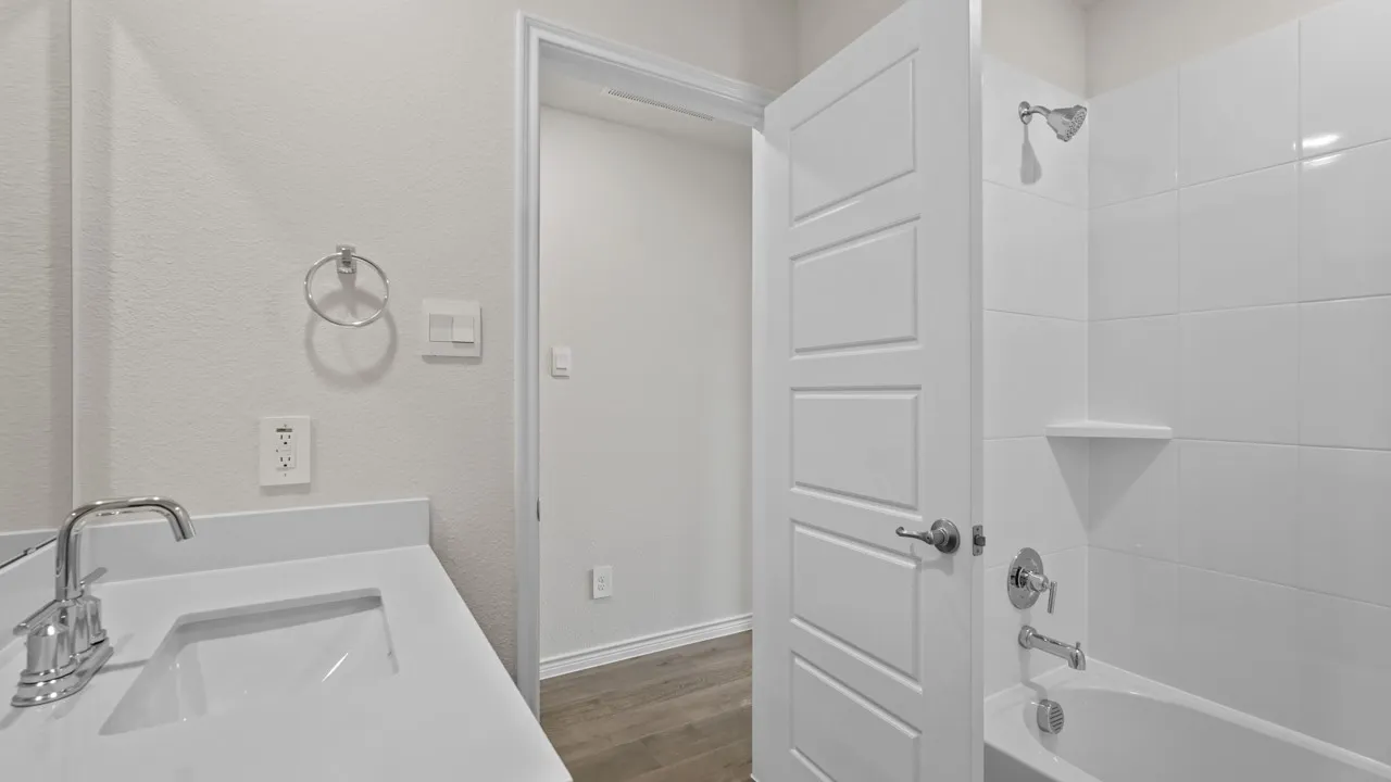 Bathroom featuring a vanity with an integrated sink, polished chrome faucet, and white countertop