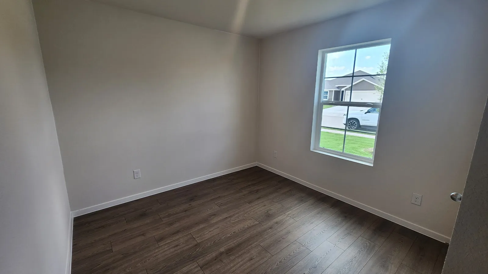 Hardwood-finish flooring complements neutral wall tones and white baseboards