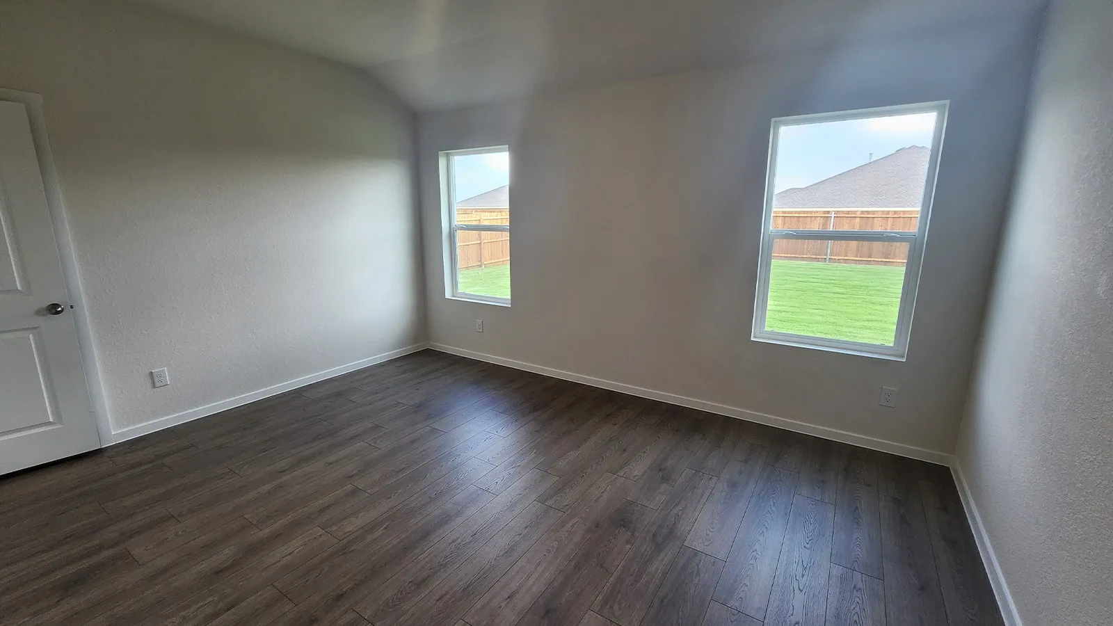 Room featuring wood-finish flooring, white baseboards, and neutral wall tones